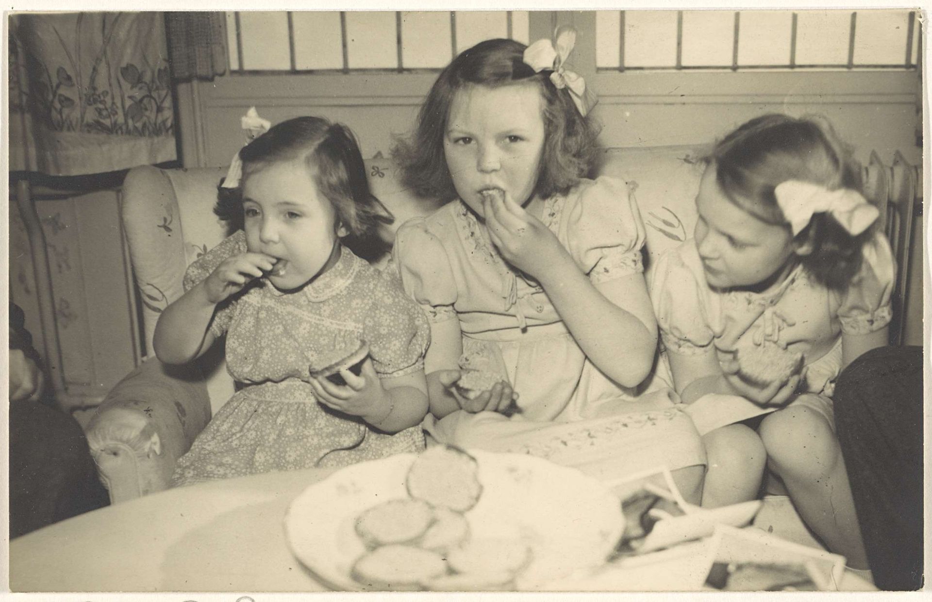 Beatrix, koningin der Nederlanden, Irene, prinses der Nederlanden, en Margriet, prinses der Nederlanden, eten beschuit met muisjes ter gelegenheid van de geboorte van Christina, prinses der Nederlanden, op 18 februari 1947 by Anonymous