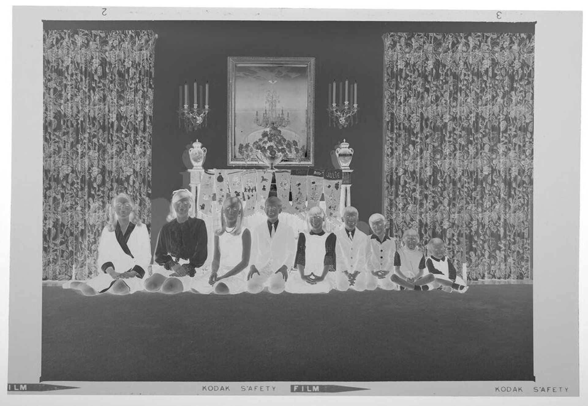 Untitled (nine children posed sitting in front of fireplace decorated with stockings) by Martin Schweig