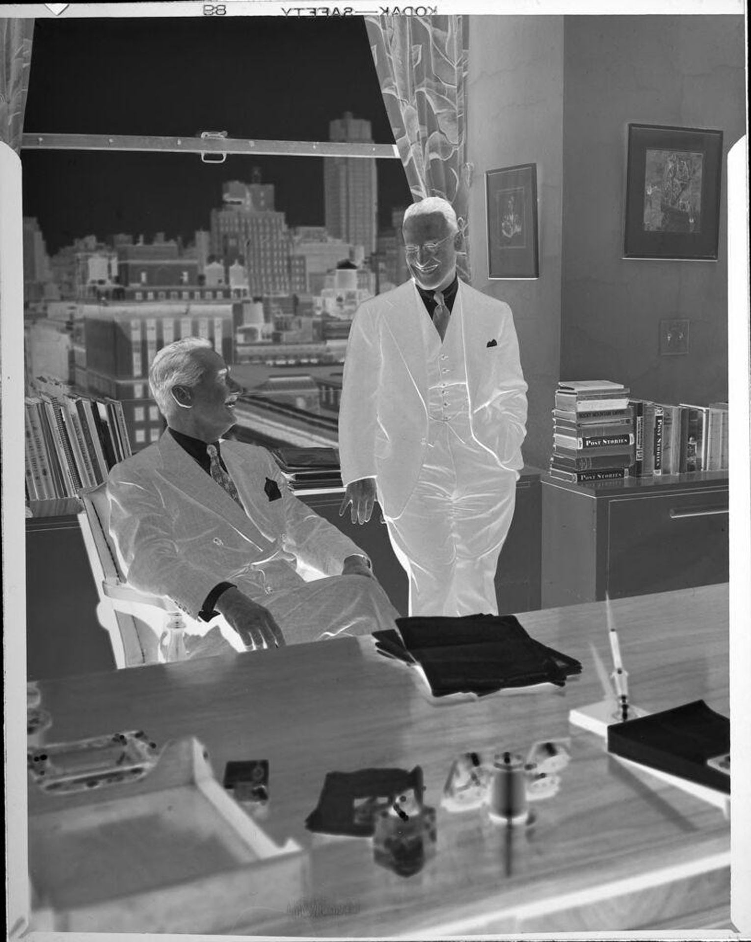 Untitled (two men in office) by Lester Cole