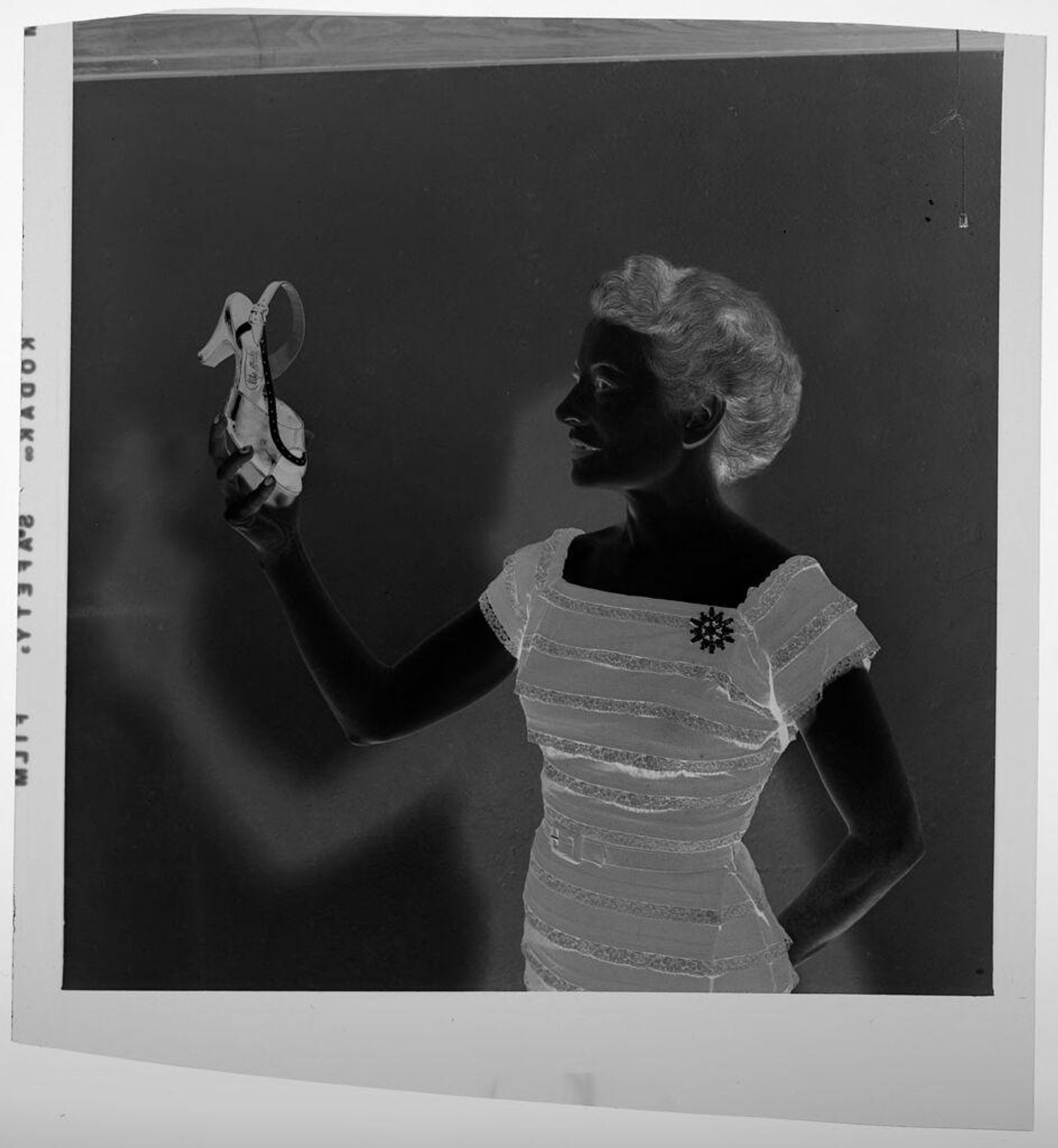 Untitled (woman holding up a shoe) by Jack Gould