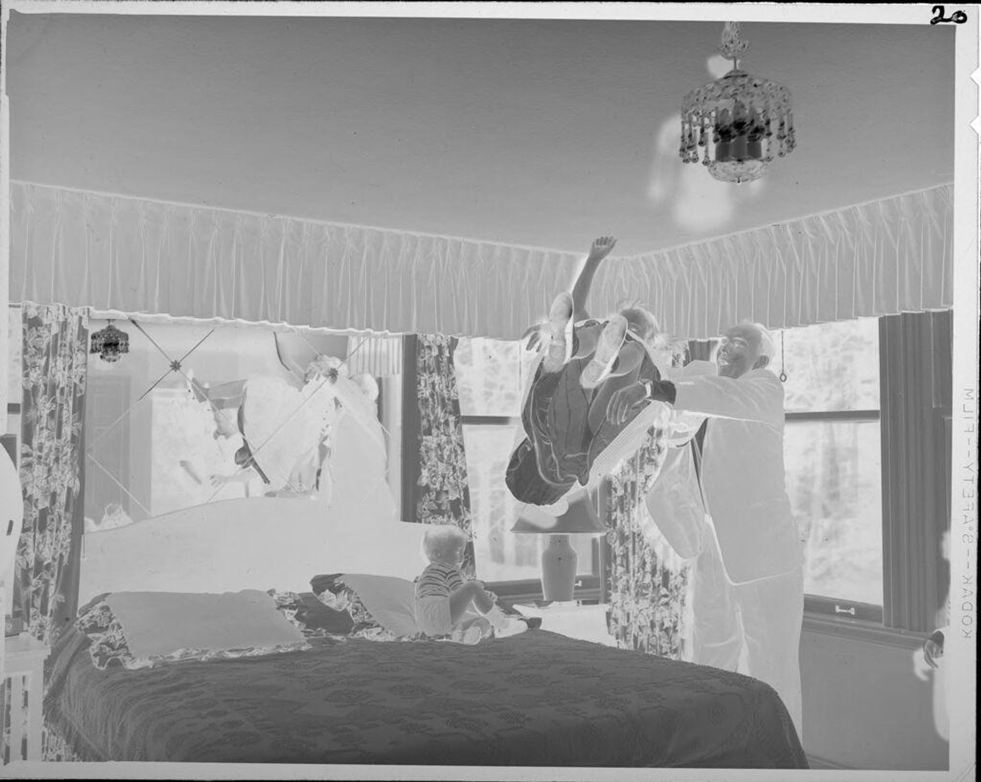 Untitled (man tossing girl onto bed) by Lucian and Mary Brown