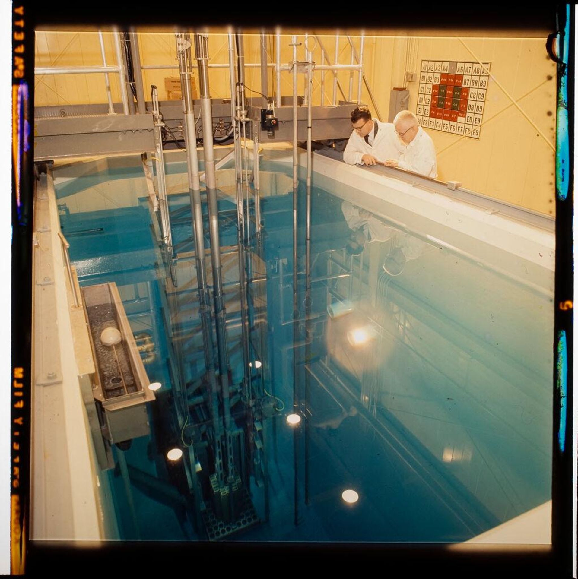Untitled (scientists looking into pool of water at research facility) by Jack Gould