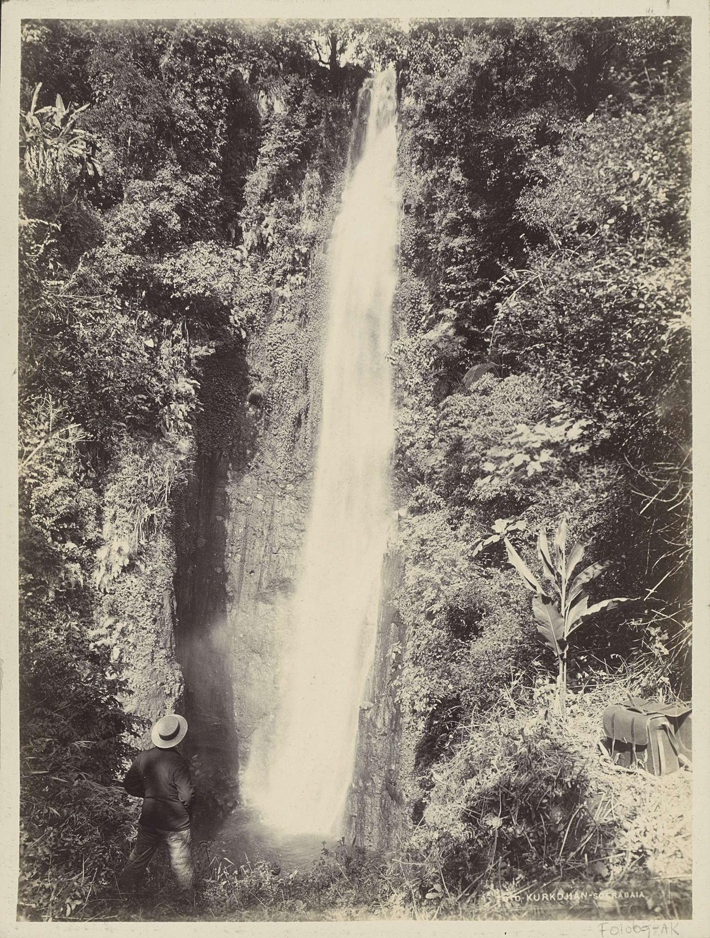 Man bekijkt een waterval in een bos van Nederlands-Indië by Onnes Kurkdjian