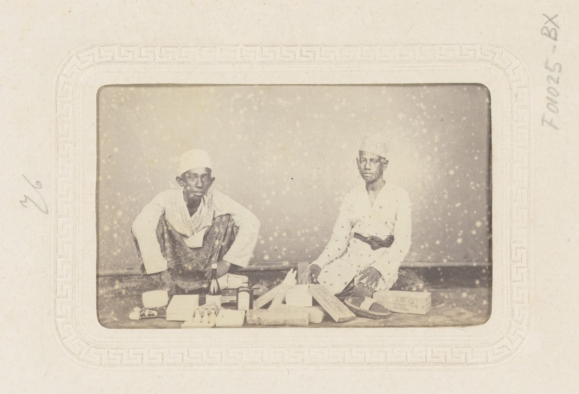 Twee jonge Indonesische kooplieden met koopwaren by Woodbury & Page