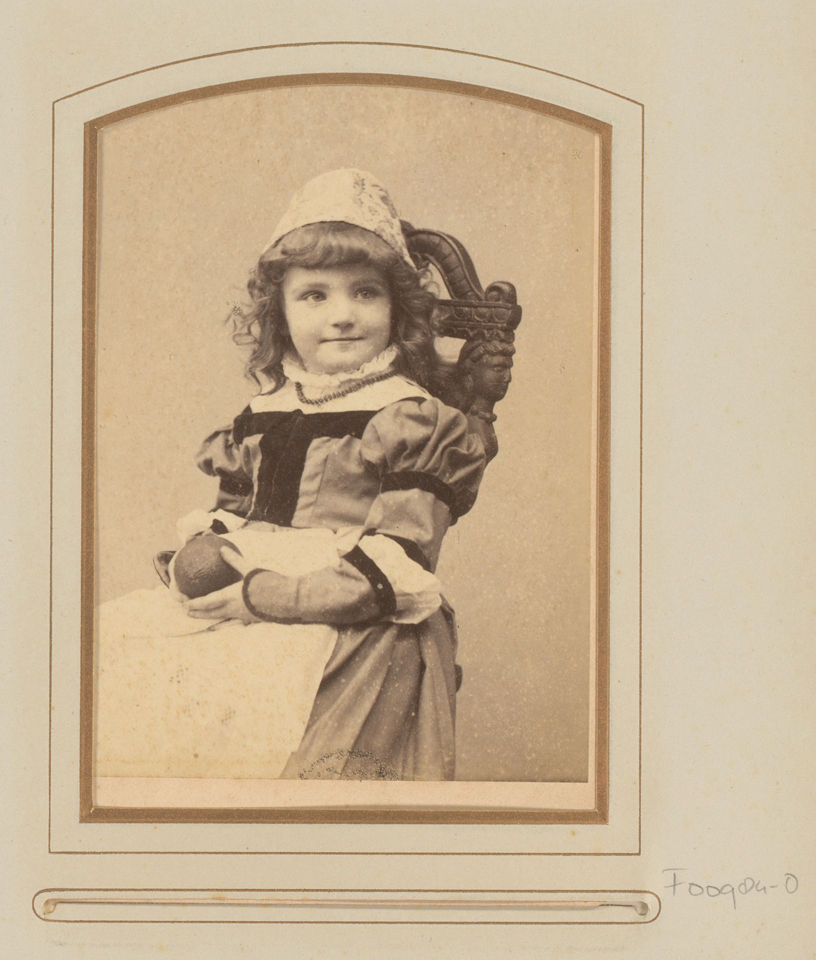 Portret van een zittend meisje in klederdracht met bal in de hand by E. Vogelsang