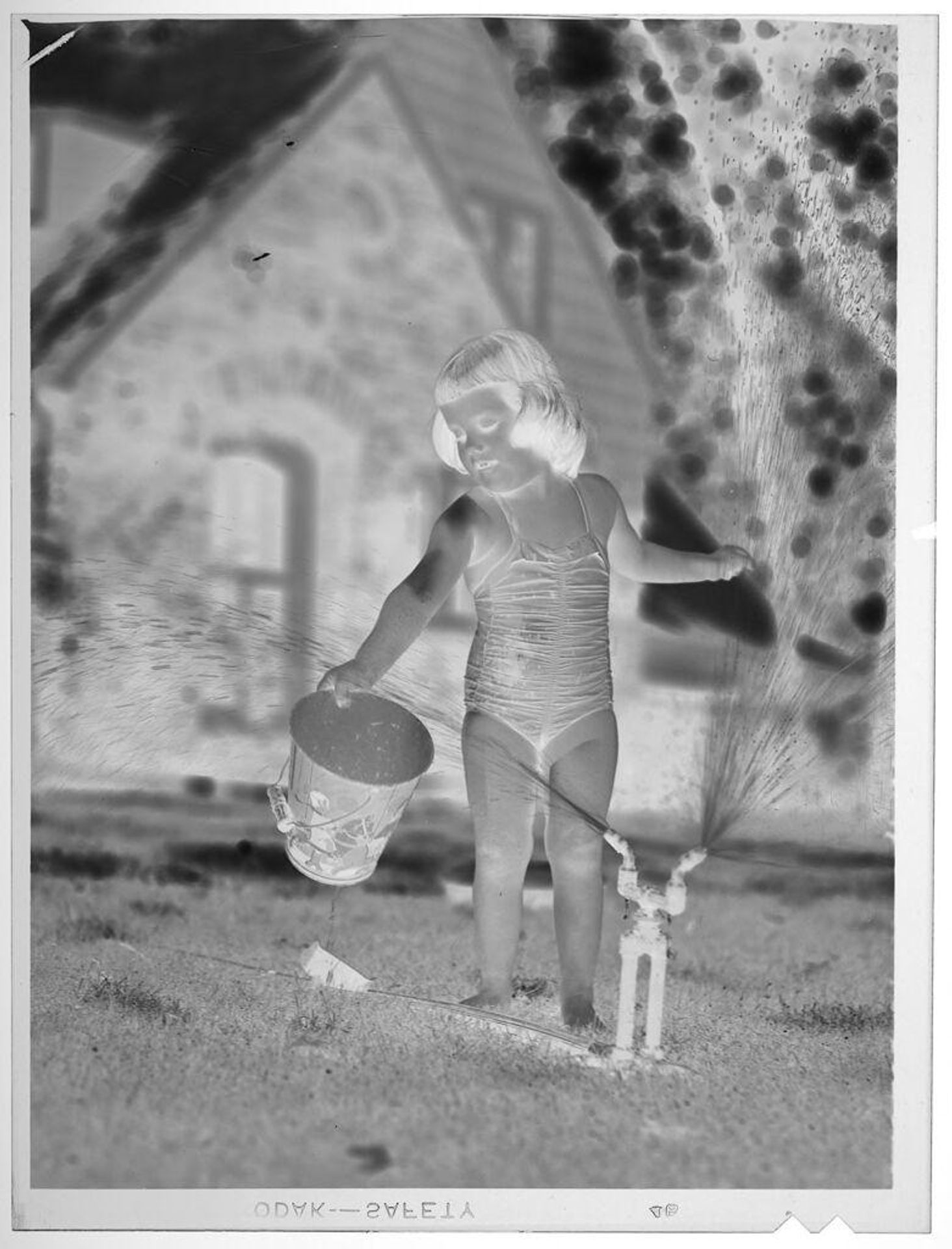 Untitled (girl playing with water hose) by Lucian and Mary Brown