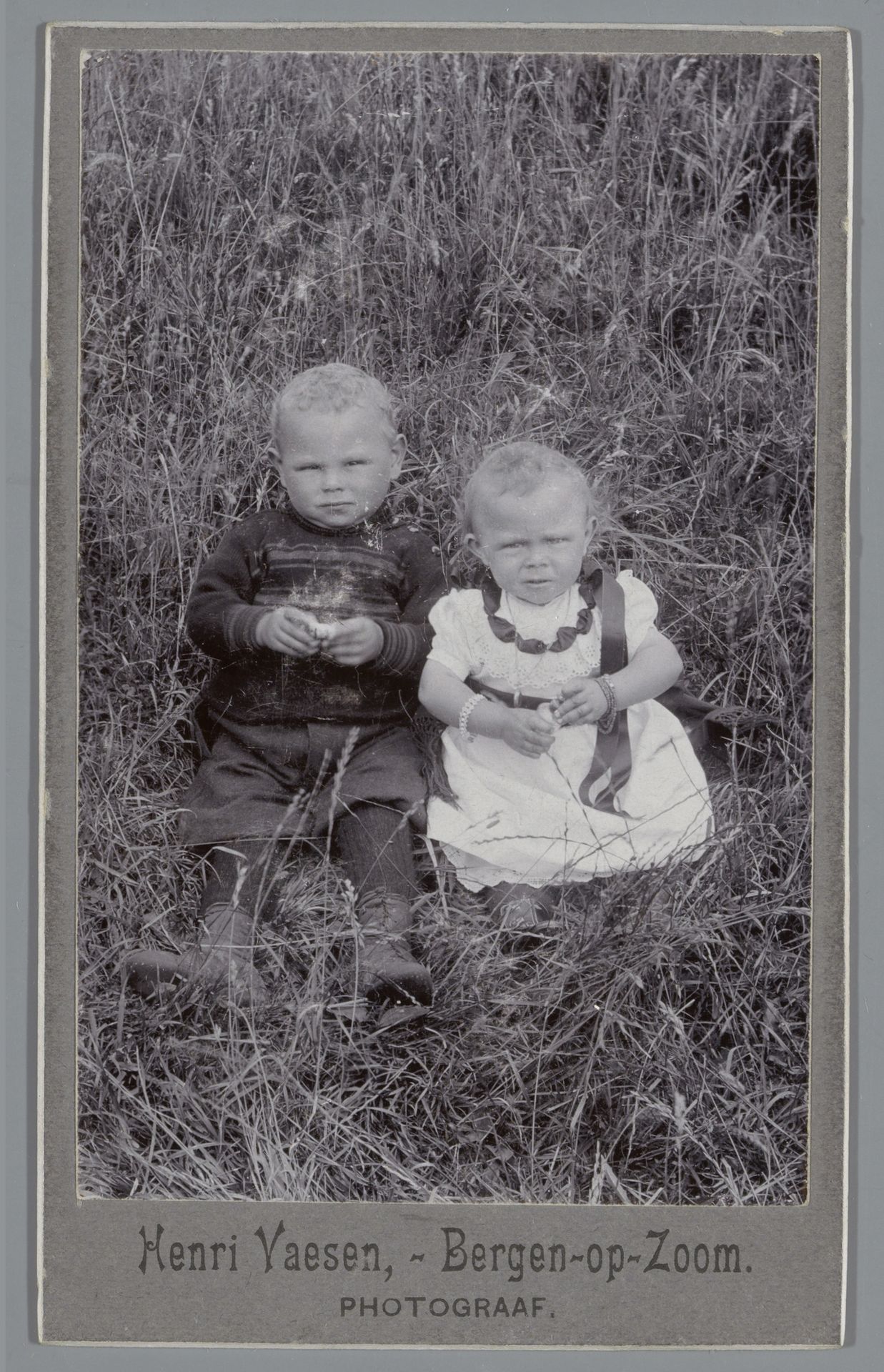 Portret van twee onbekende kinderen in een grasveld by Henri Vaesen