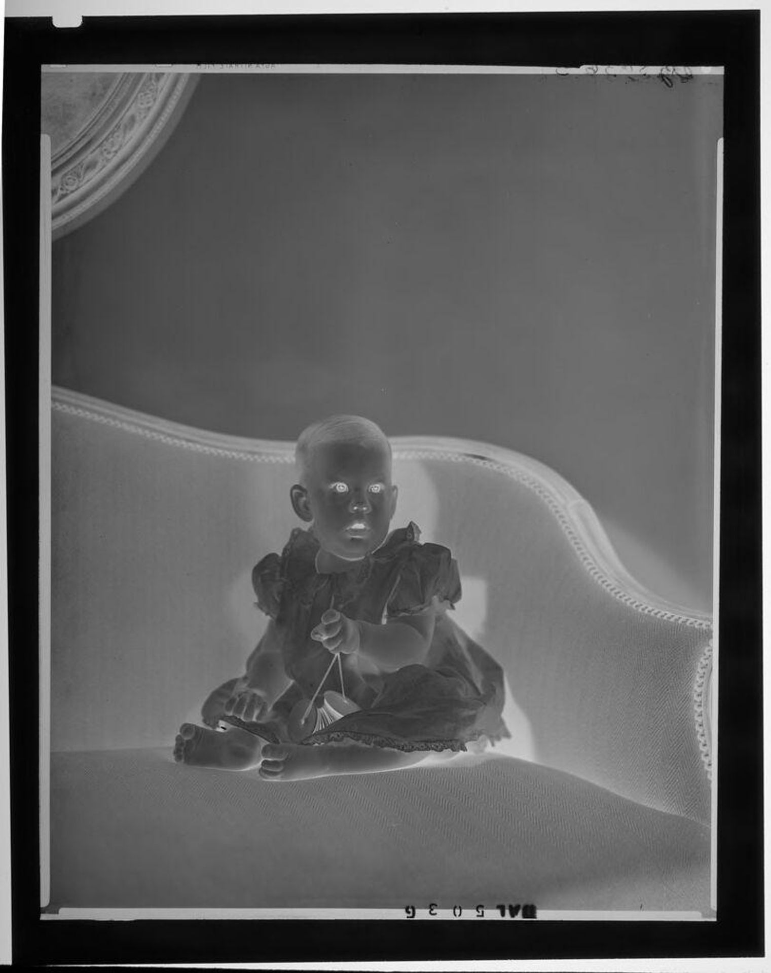 Untitled (baby seated in corner of formal couch) by Paul Gittings