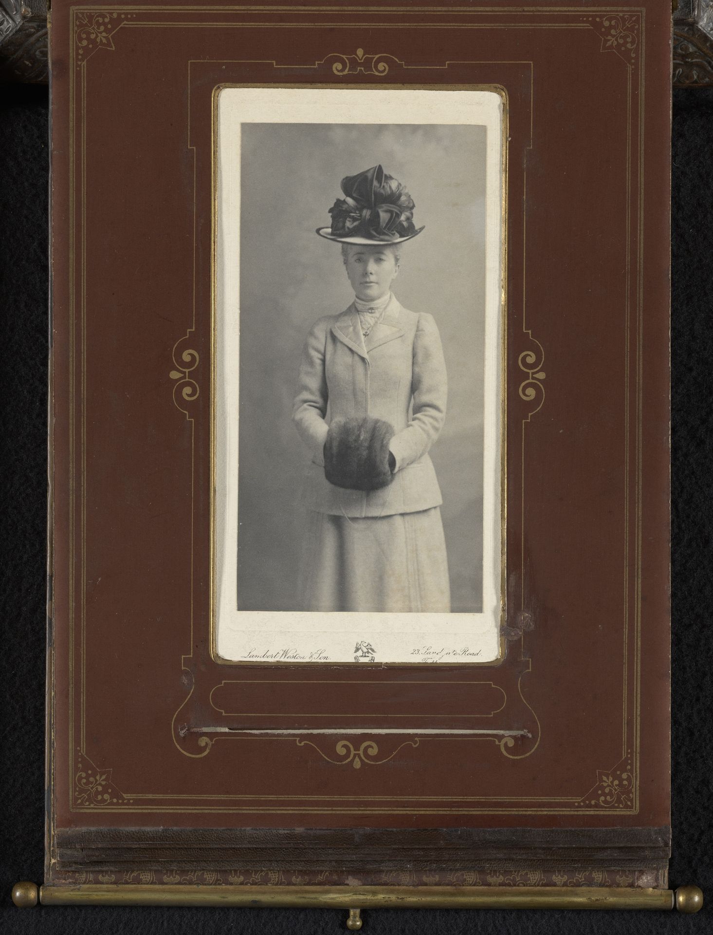 Portret van een staande vrouw met hoed en mof by Lambert Weston