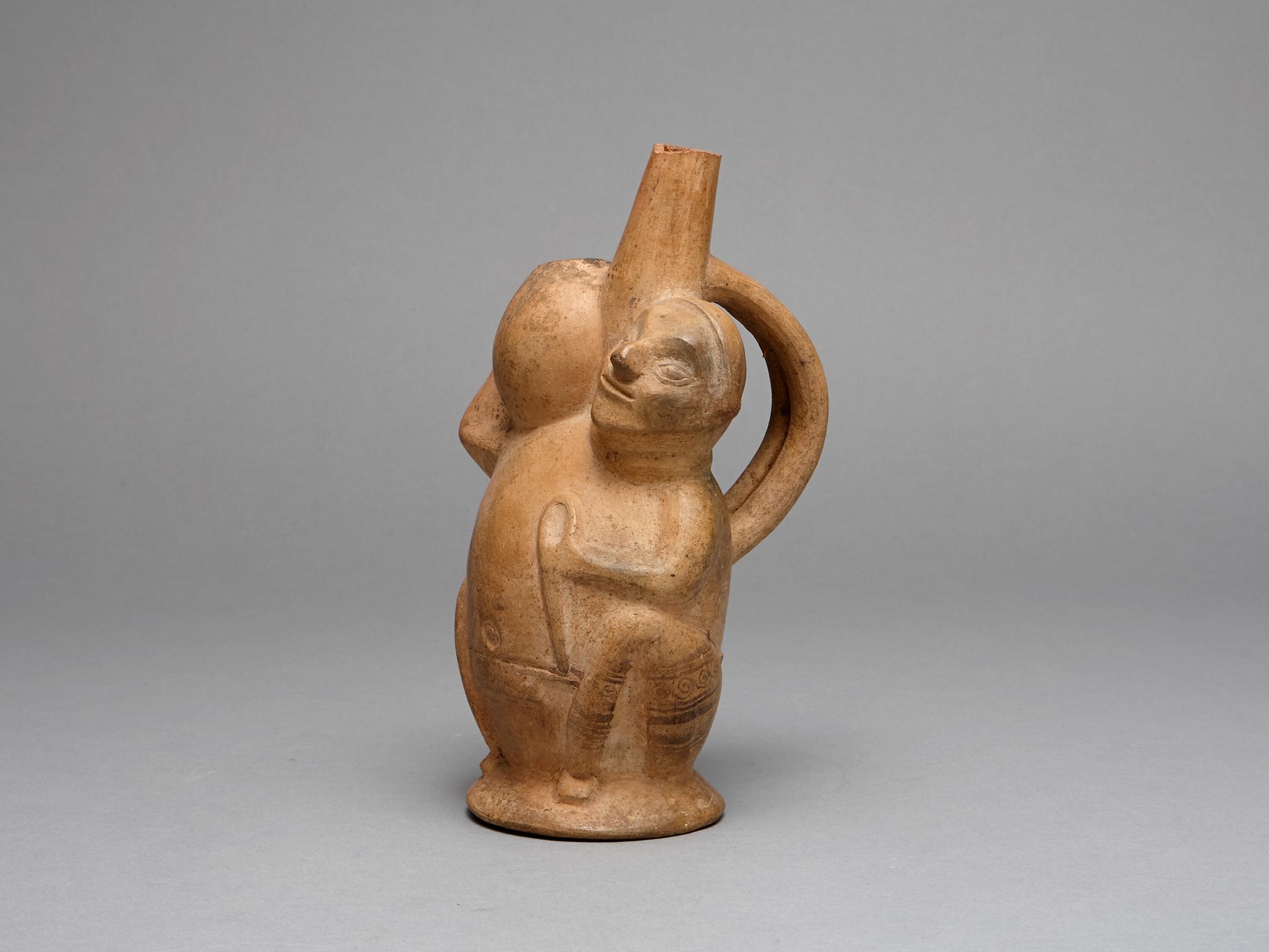Handle Spout Vessel in the Form of a Seated Man Carrying a Jar by Lambayeque