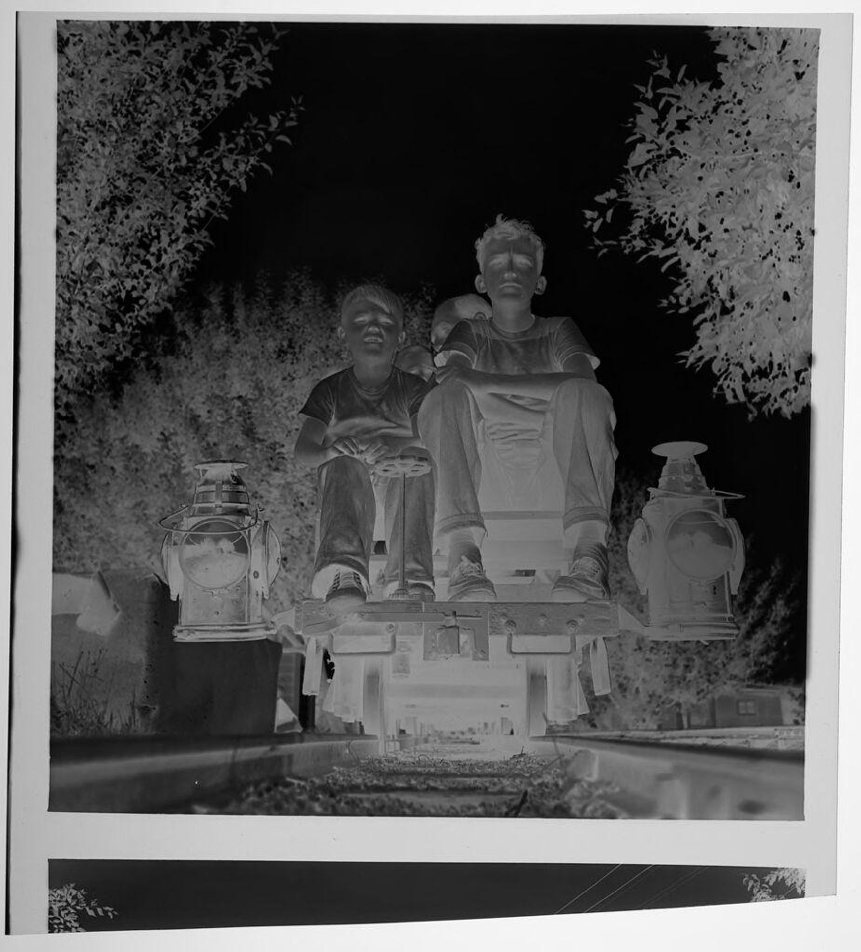 Untitled (two children sitting on front of mini train on tracks) by Jack Gould