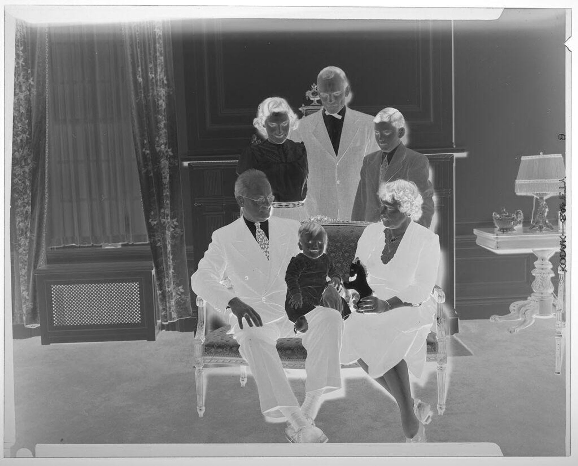 Untitled (five family members posed in living room looking at baby on grandfather's lap) by Martin Schweig