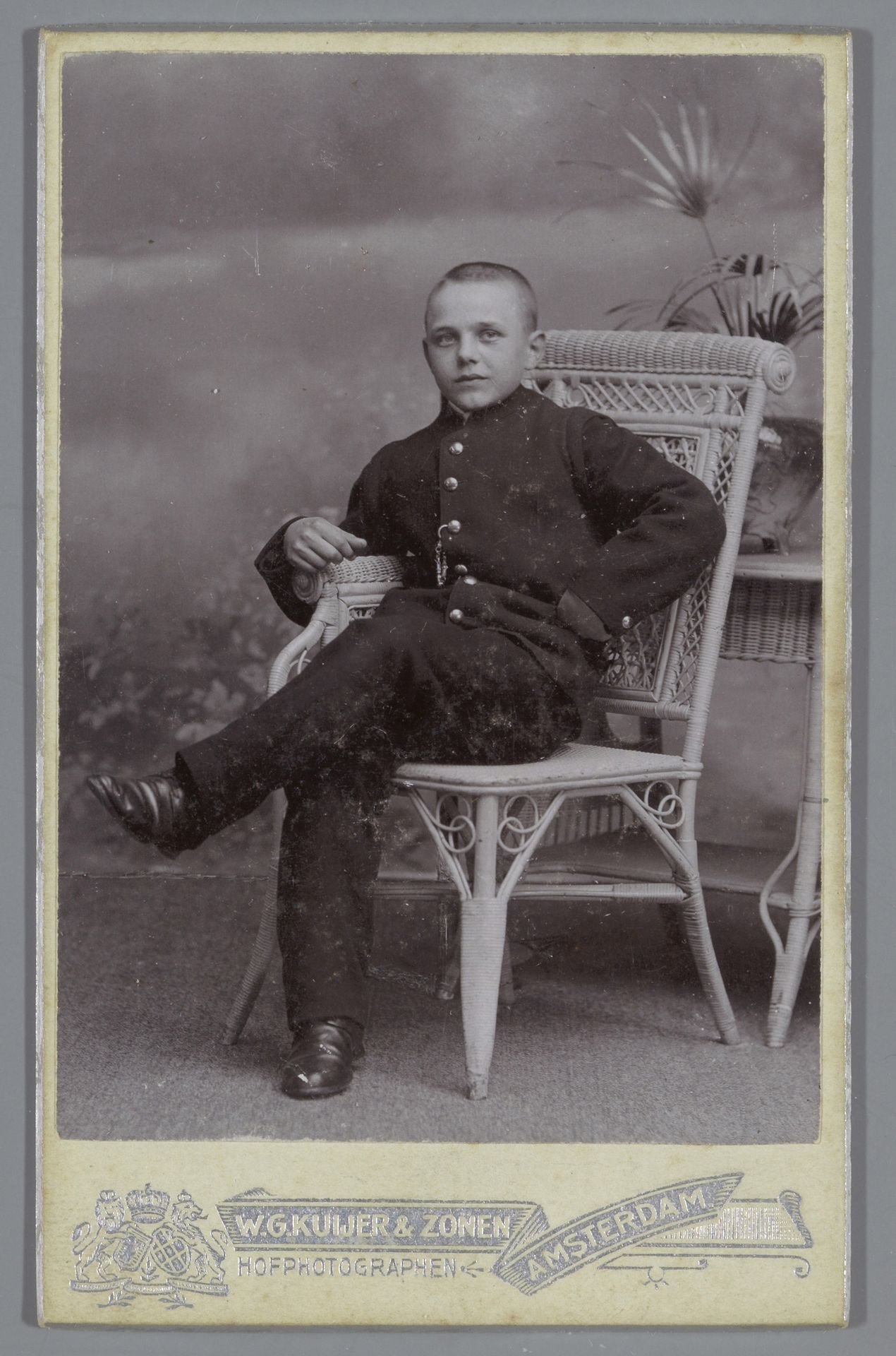 Portret van een onbekende zittende jongen in uniform by W.G. Kuijer & Zonen