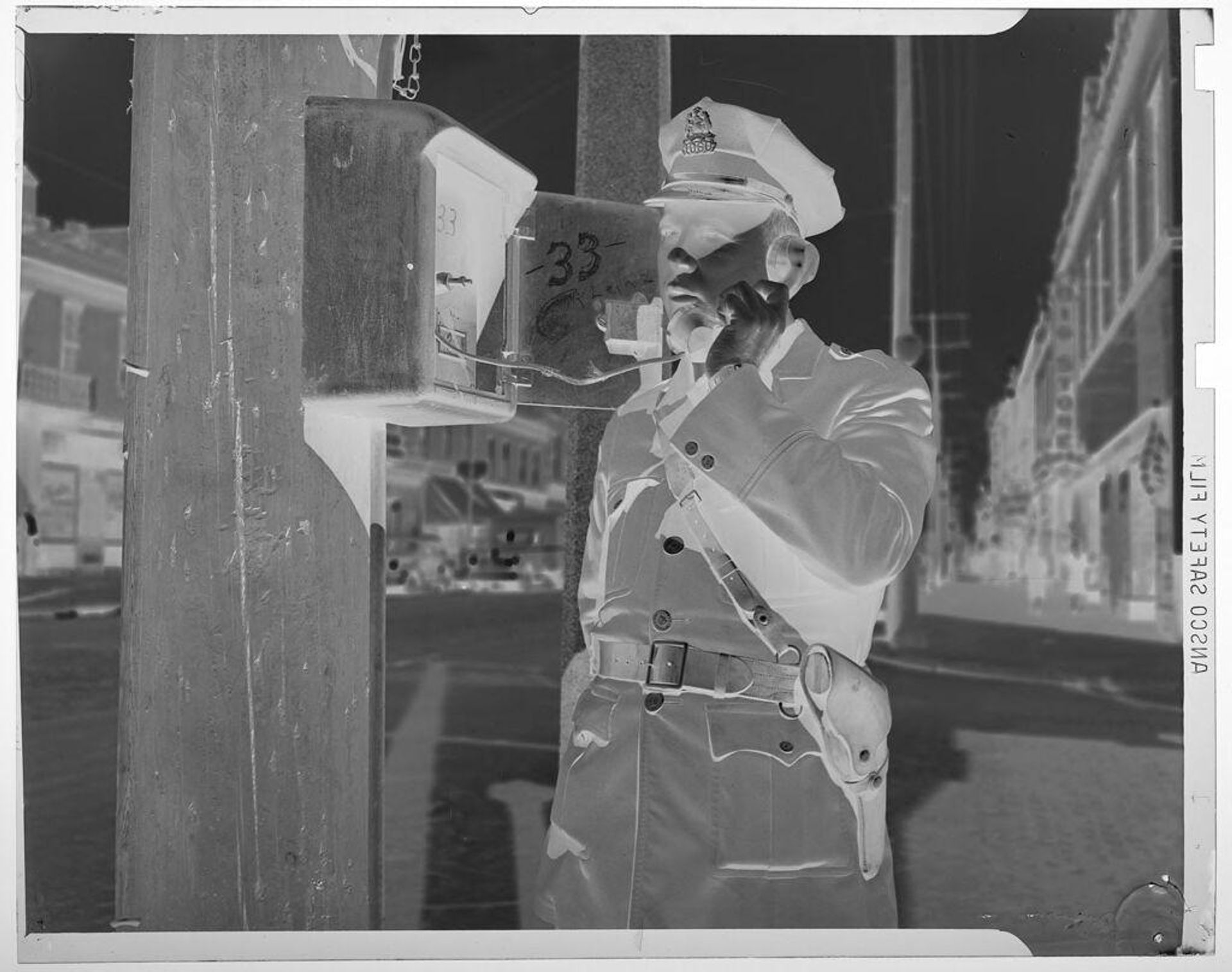 Untitled (officer on outdoor emergency telephone) by Jack Gould