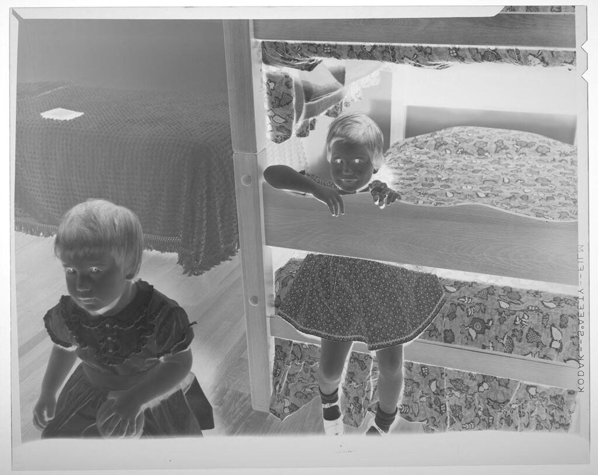 Untitled (young girl posed sitting on bottom of bunk bed in bedroom with another girl standing on floor) by Martin Schweig