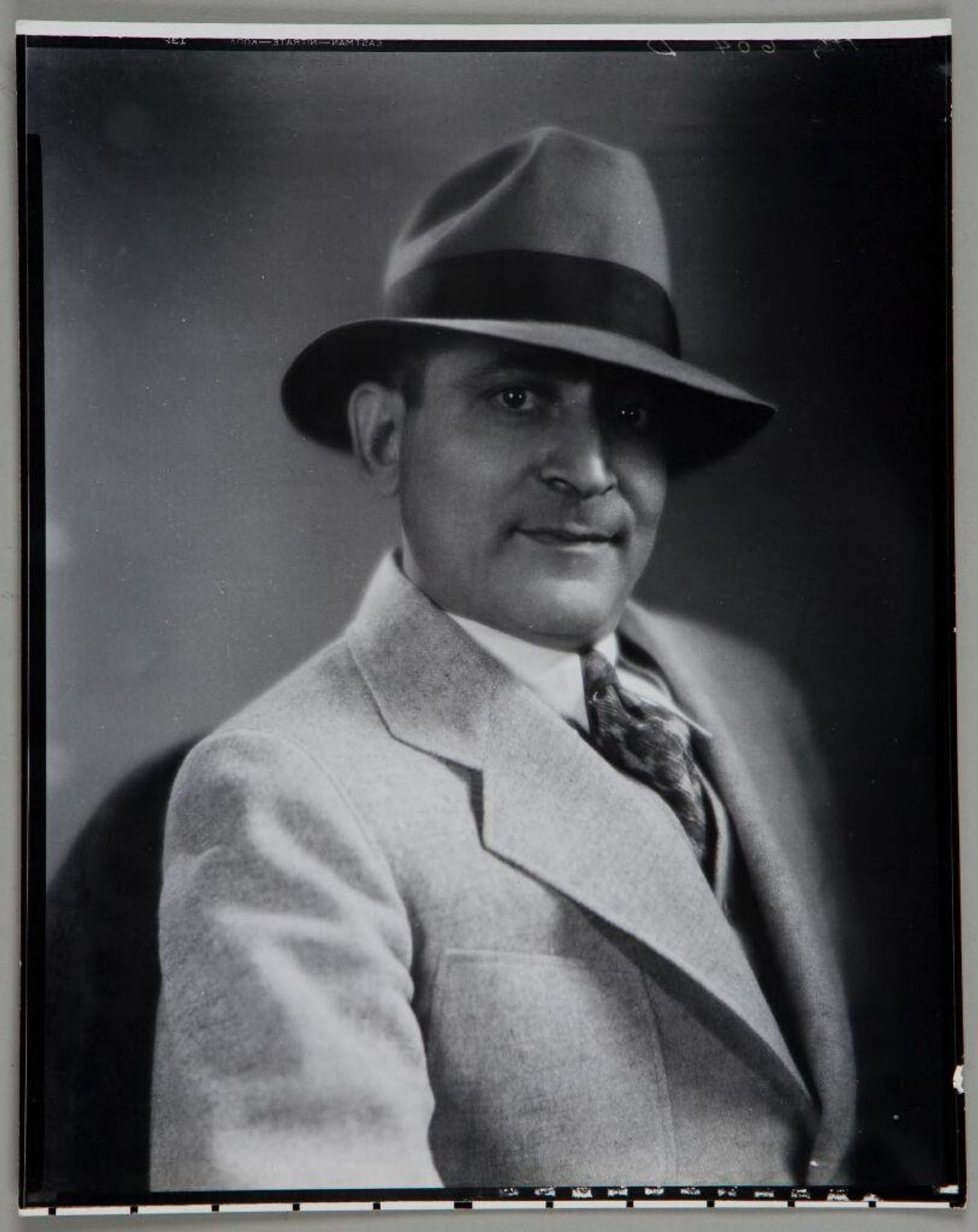 Untitled (bust length portrait of man in suit and fedora hat) by Paul Gittings