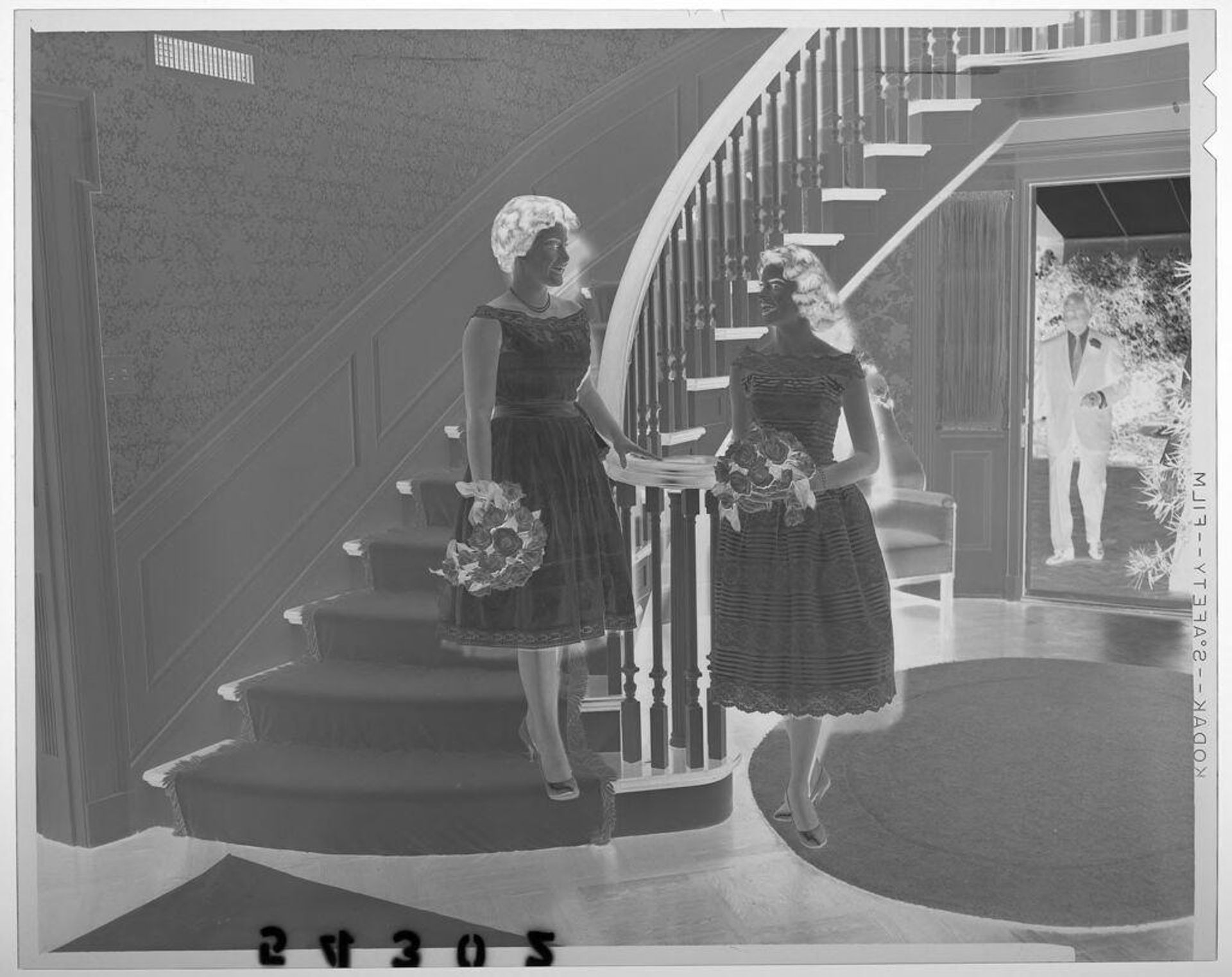 Untitled (two young women holding flower bouquets posing at bottom of fancy staircase) by Martin Schweig