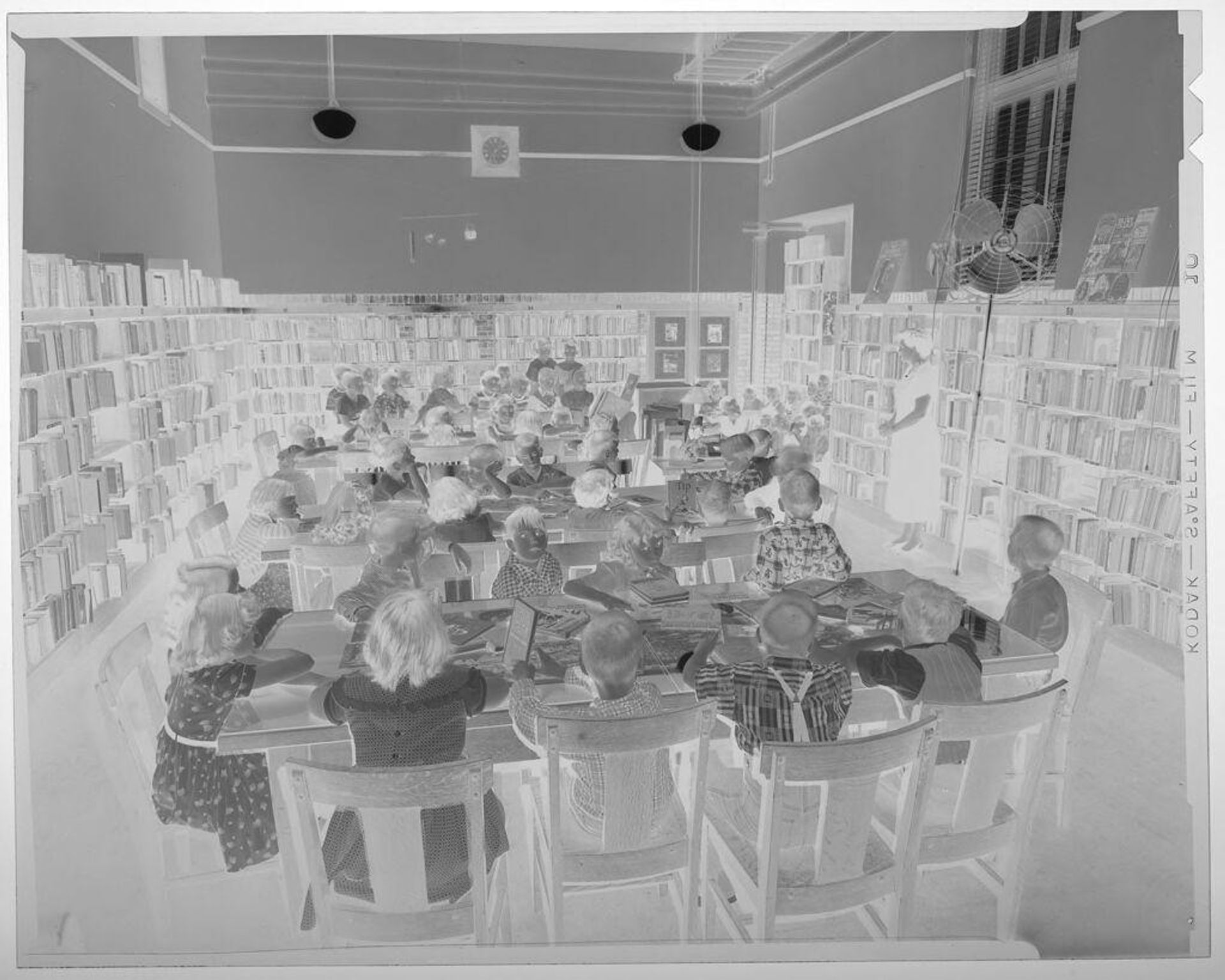 Untitled (children at tables inside library) by Jack Gould
