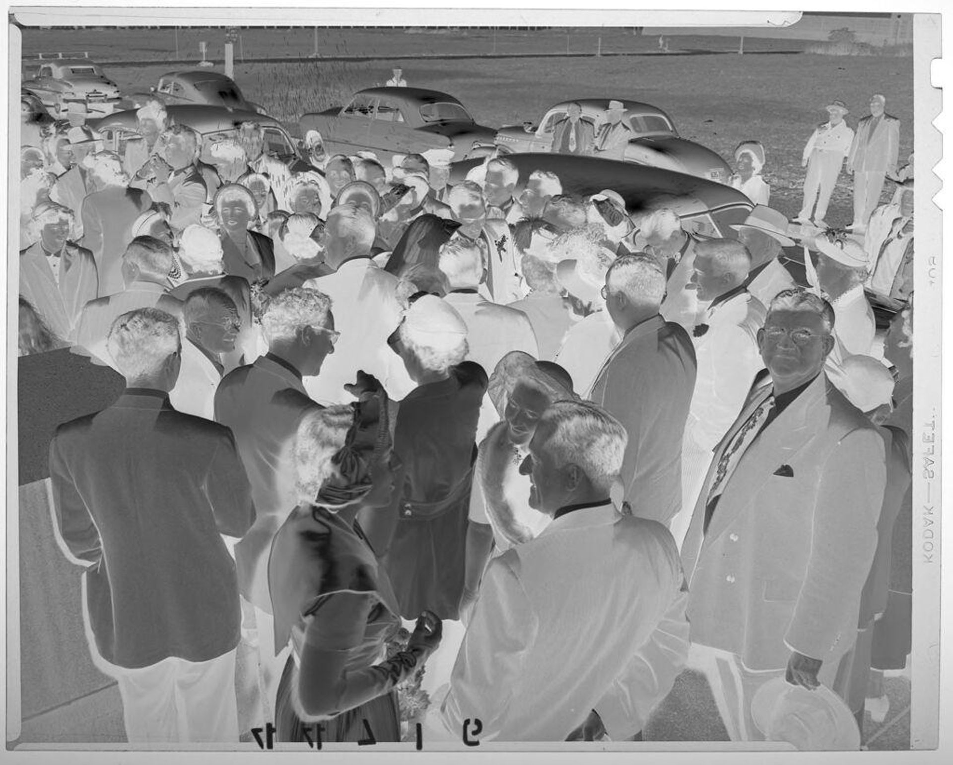 Untitled (group gathered outside with some throwing rice as wedding party proceeds through) by Martin Schweig