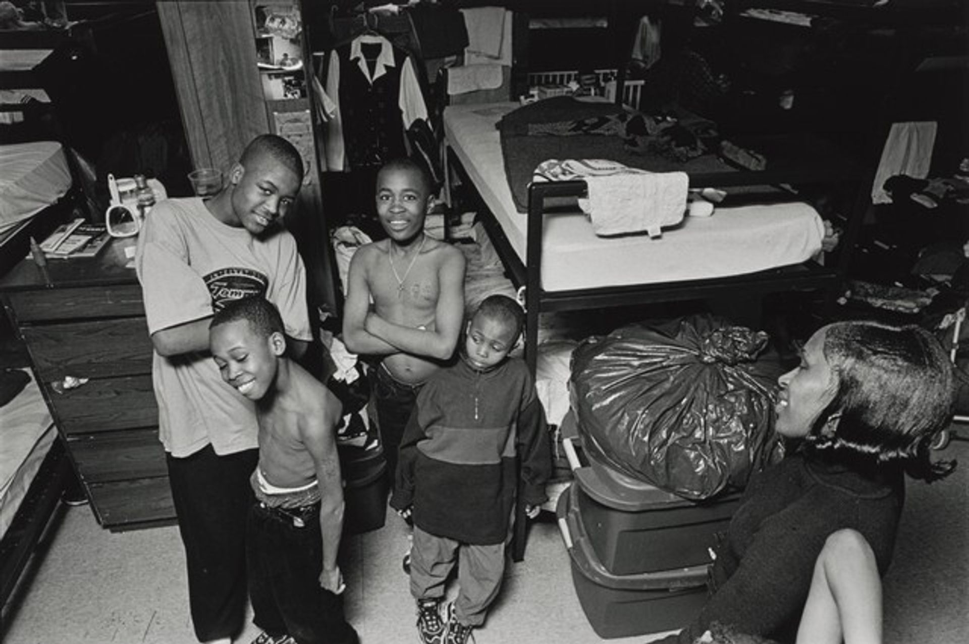 Standing between their bunk beds, Margie admires her four sons: Johnny, 13, Pierre, 11, Jamont, 9, and Johnnell, 11. She always took care of her kids until she fell in love with a drug addict and became addicted herself. Her children's world fell apart and they became homeless residents at the mission. Olive Branch Mission, Chicago. by Donna Ferrato