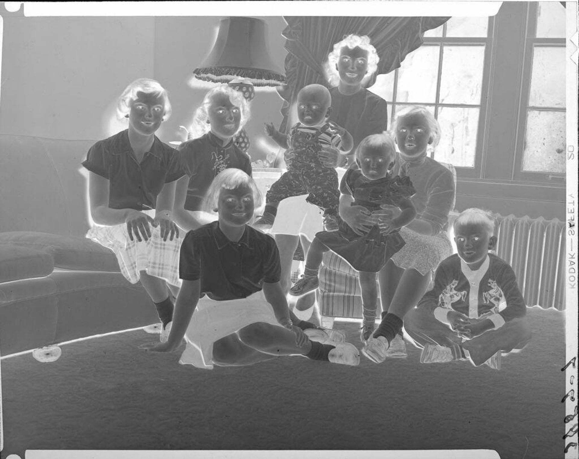 Untitled (woman and children in family room) by John Howell