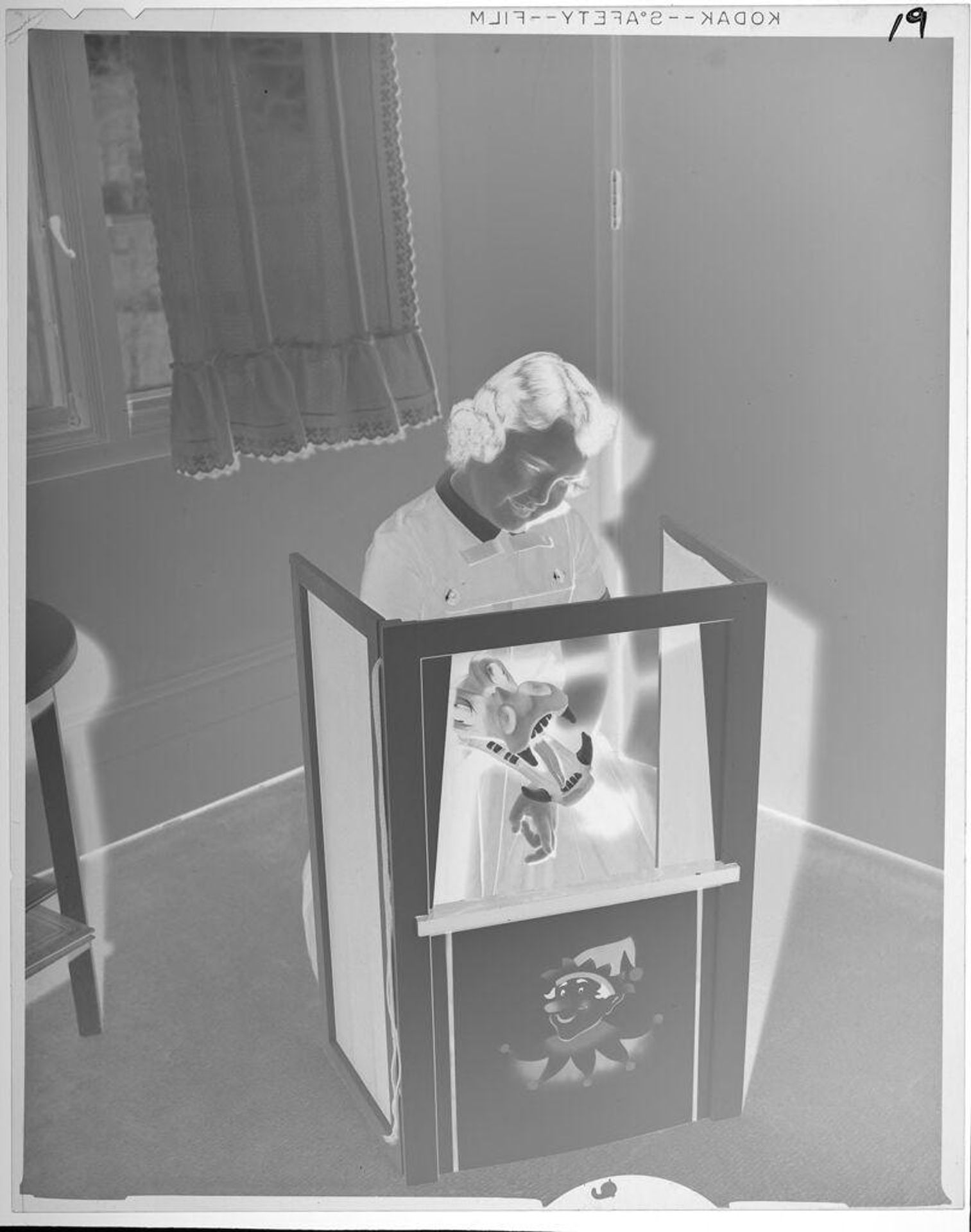 Untitled (girl performing puppet show in homemade theater) by Lucian and Mary Brown