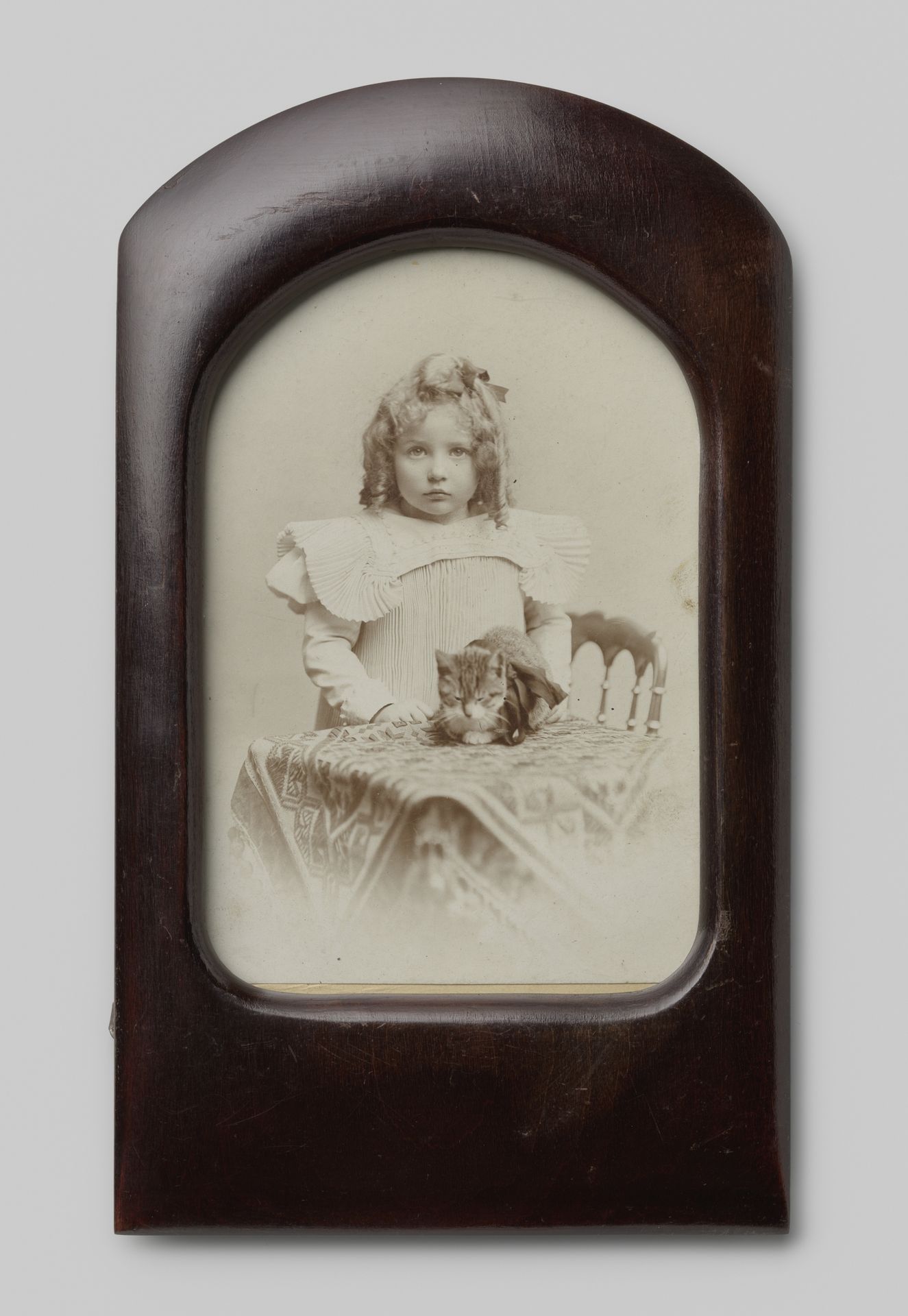 Portret van een onbekend meisje en een poes op tafel by Max Büttinghausen