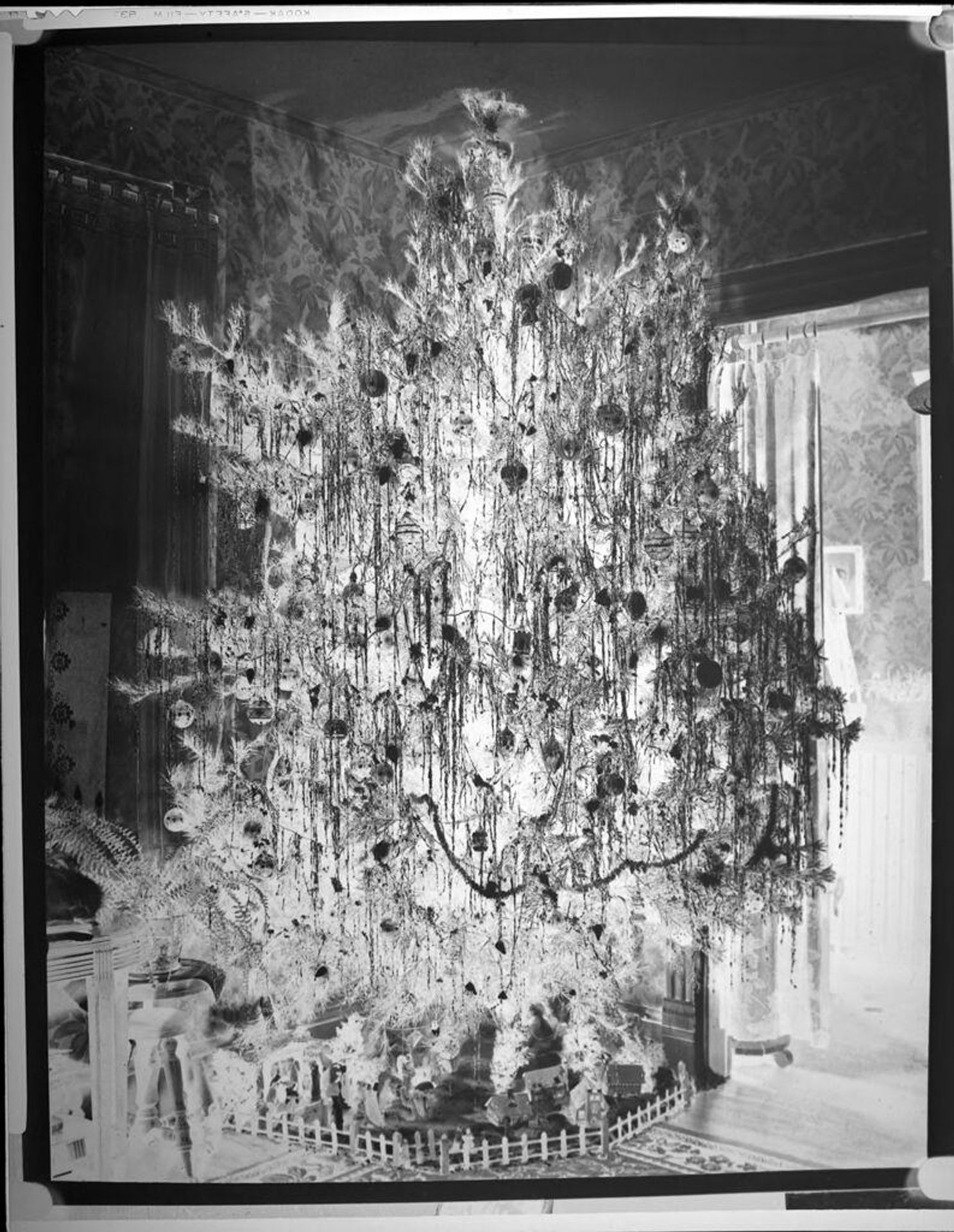 Untitled (large Christmas tree, tinsel, toy village) by Harris & Ewing