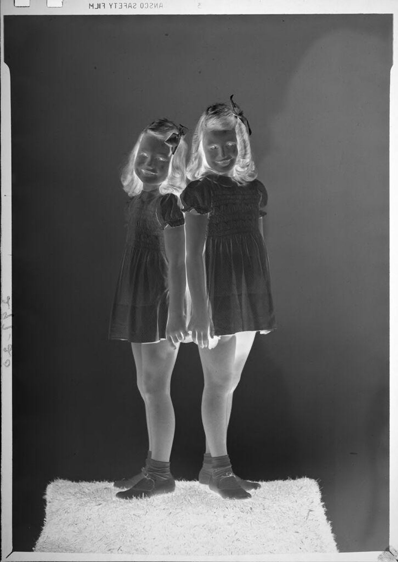 Untitled (portrait of two girls standing back-to-back) by John Howell