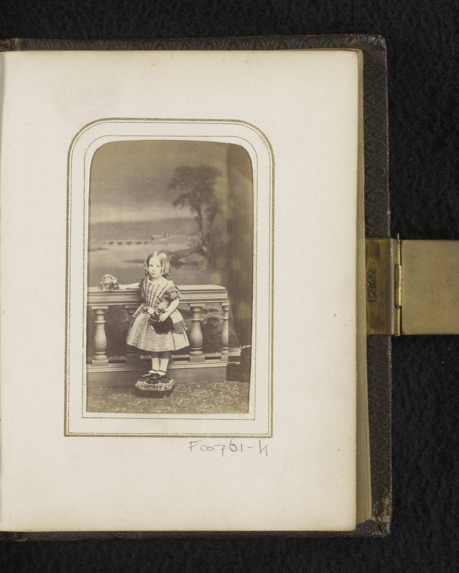 Portret van een meisje met pop, staand bij een balustrade by S.J. Wiseman