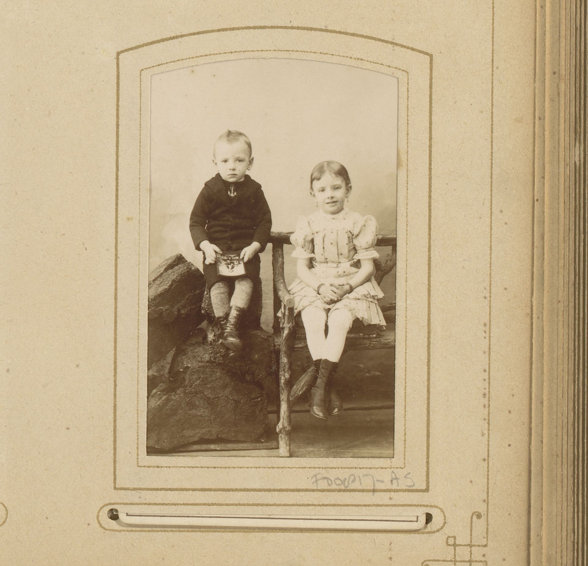 Studioportret van een zittende jongen en meisje by G.A. Mögle & Co