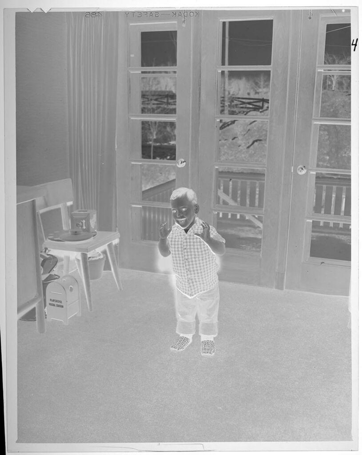 Untitled (smiling boy standing in playroom) by Lucian and Mary Brown