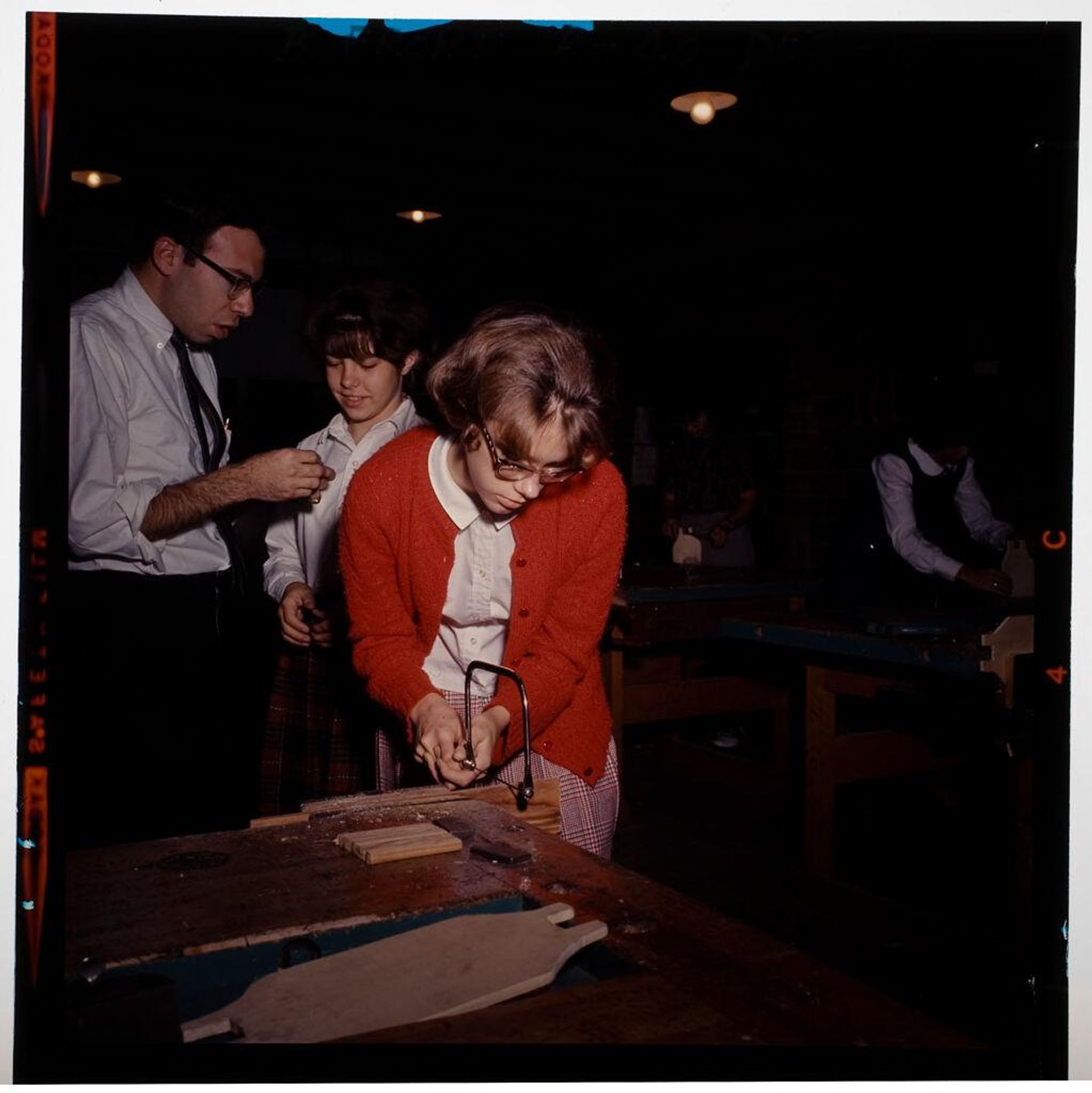 Untitled (children in woodshop class, girl using bandsaw) by Jack Gould
