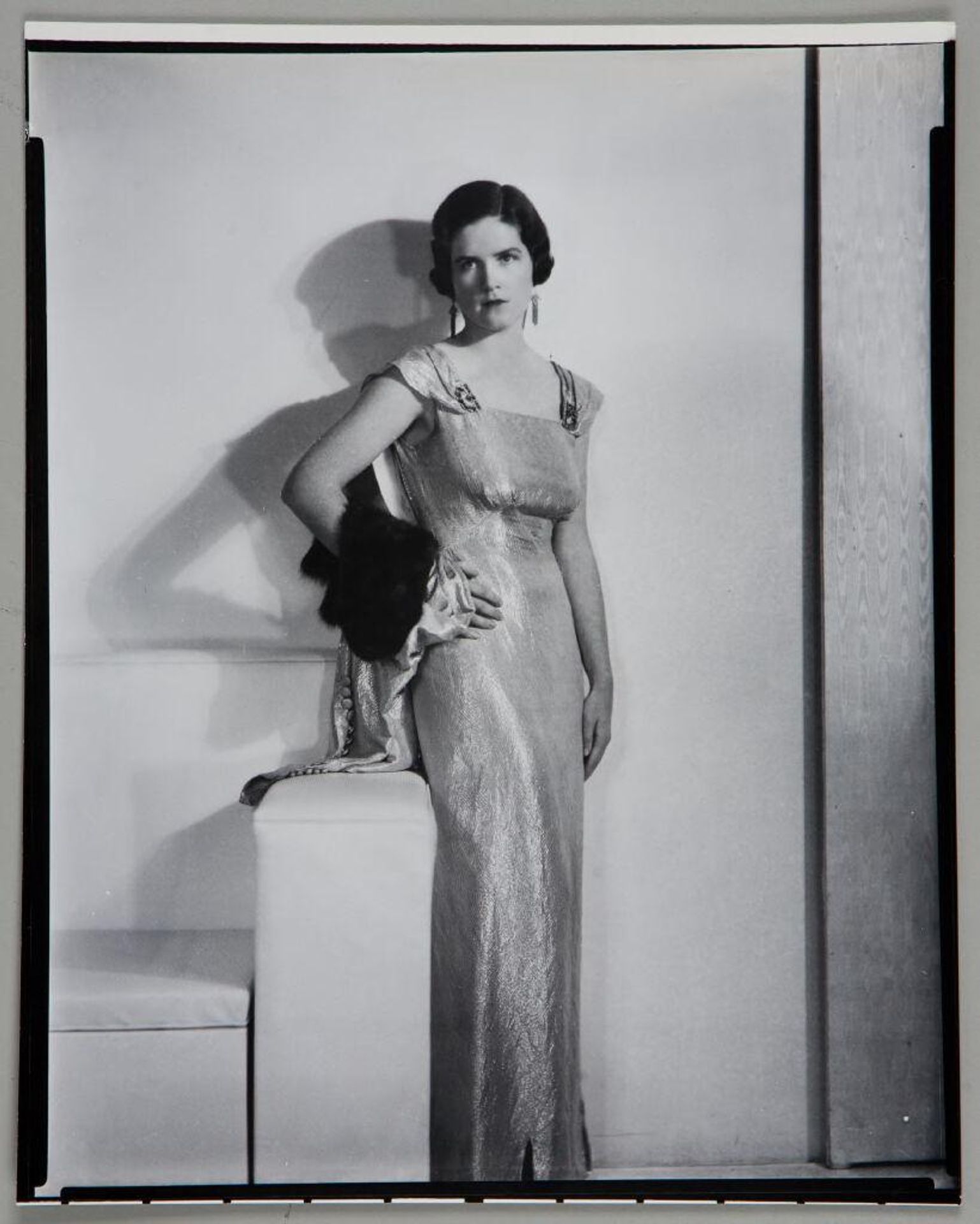 Untitled (portrait of a woman in long dress with right hand on hip, fur trimmed garment over arm) by Paul Gittings