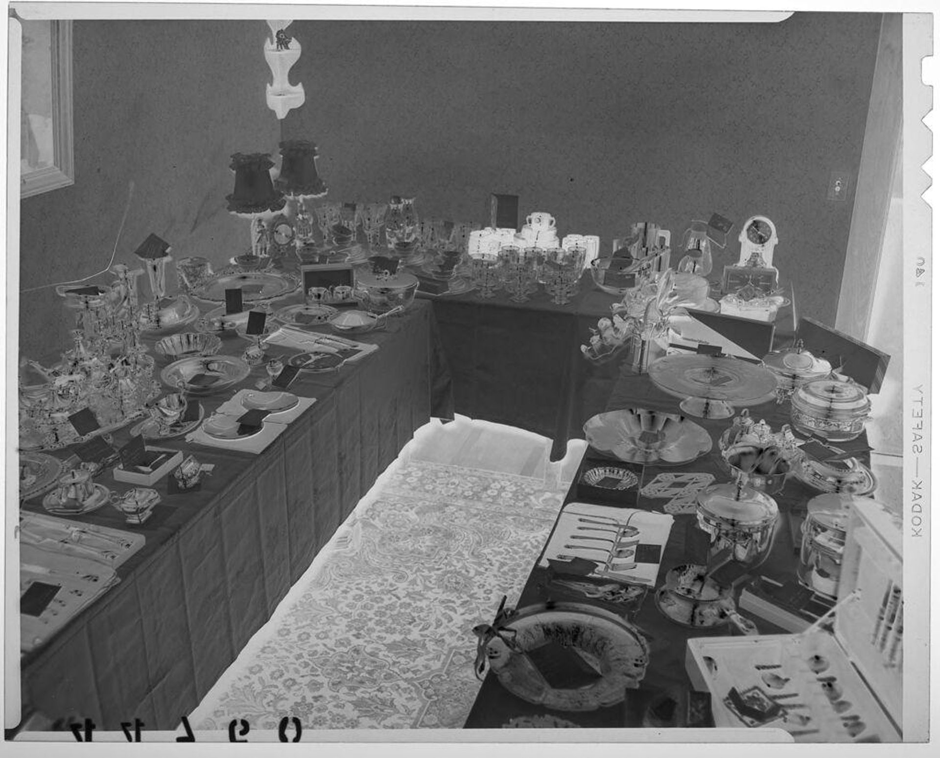 Untitled (elevated view of wedding gifts arranged on three tables) by Martin Schweig