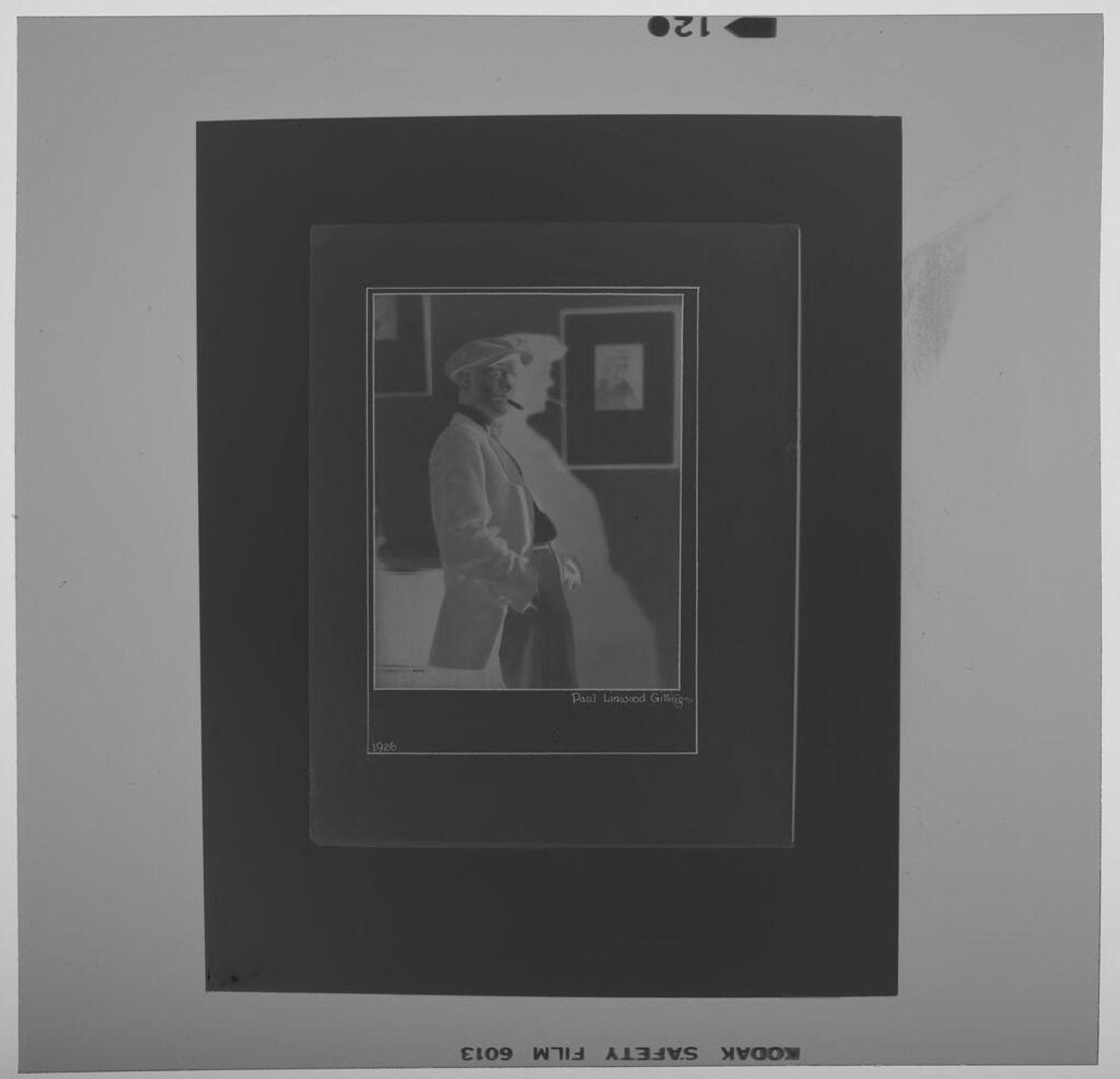 Untitled (photograph of a man with cigar standing in front of other photographs) by Paul Gittings