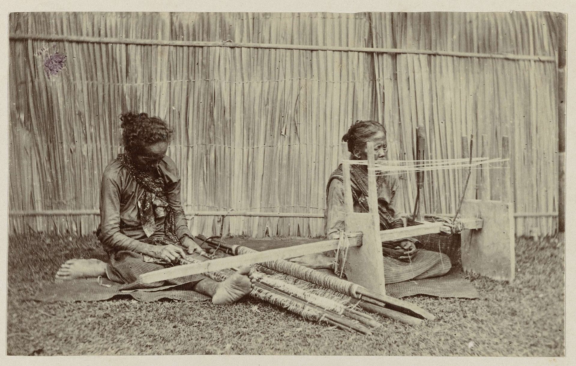 Twee vrouwen aan een weefgetouw by Woodbury & Page
