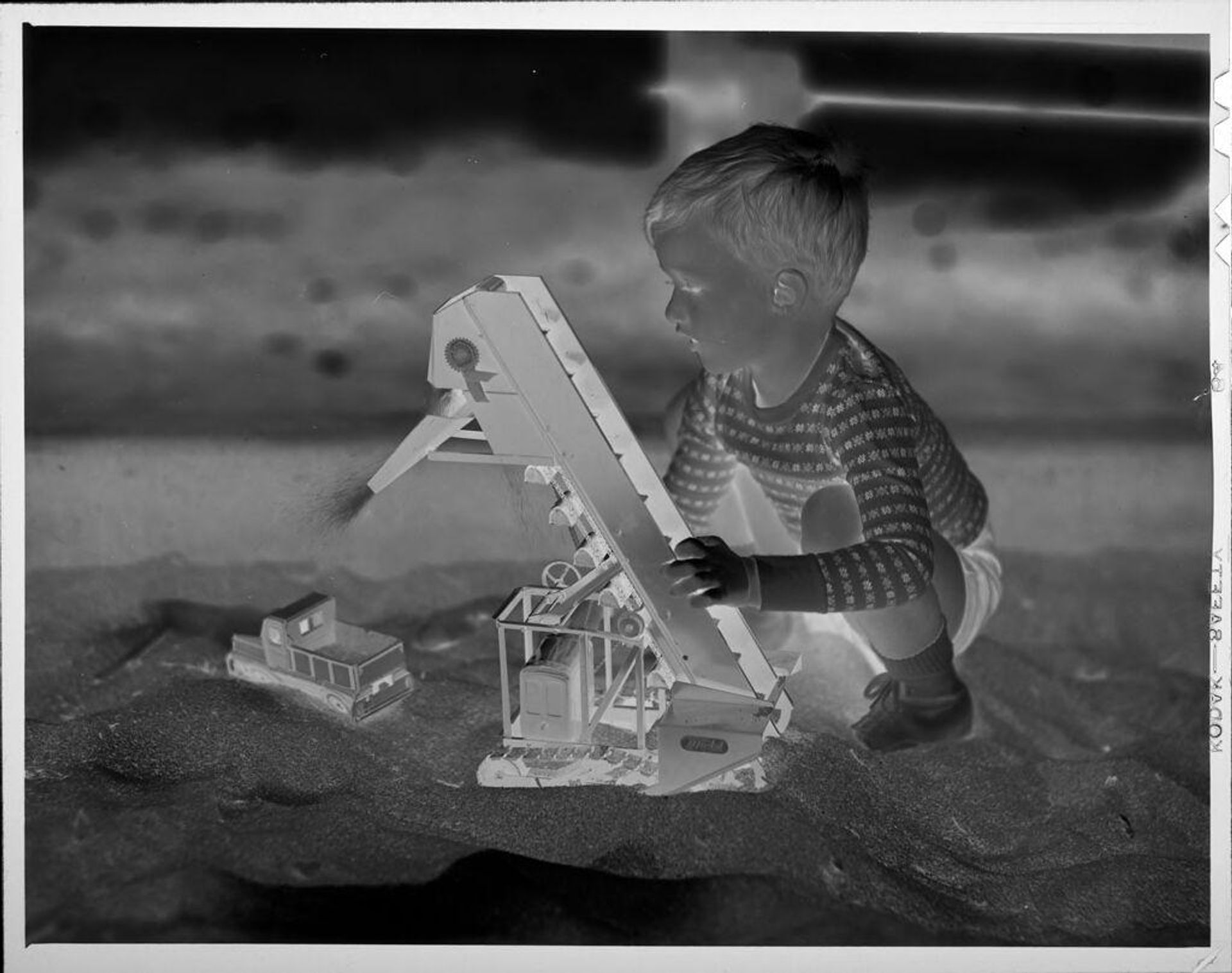 Untitled (boy playing with truck in sandbox) by Lucian and Mary Brown