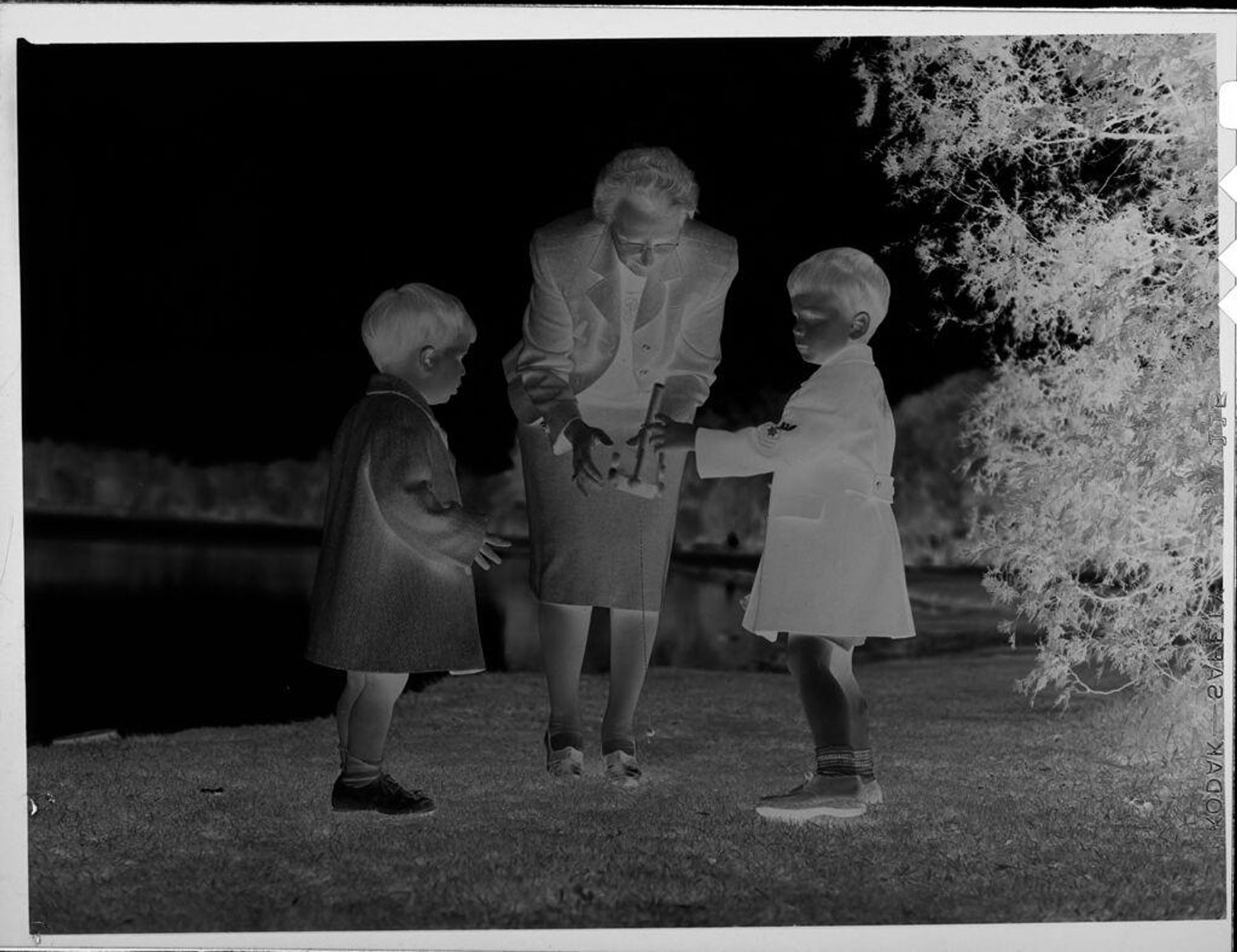 Untitled (woman and two boys outside by lake) by Lucian and Mary Brown