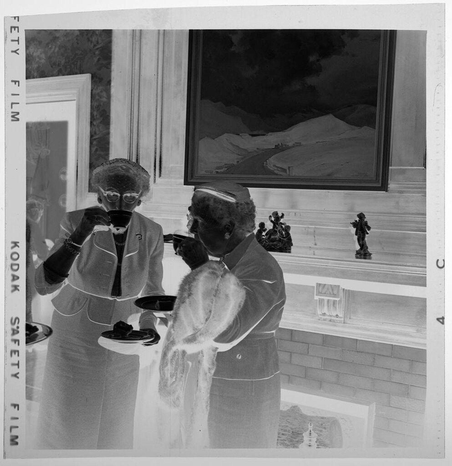 Untitled (two women drinking tea in front of fireplace and painting) by Jack Gould