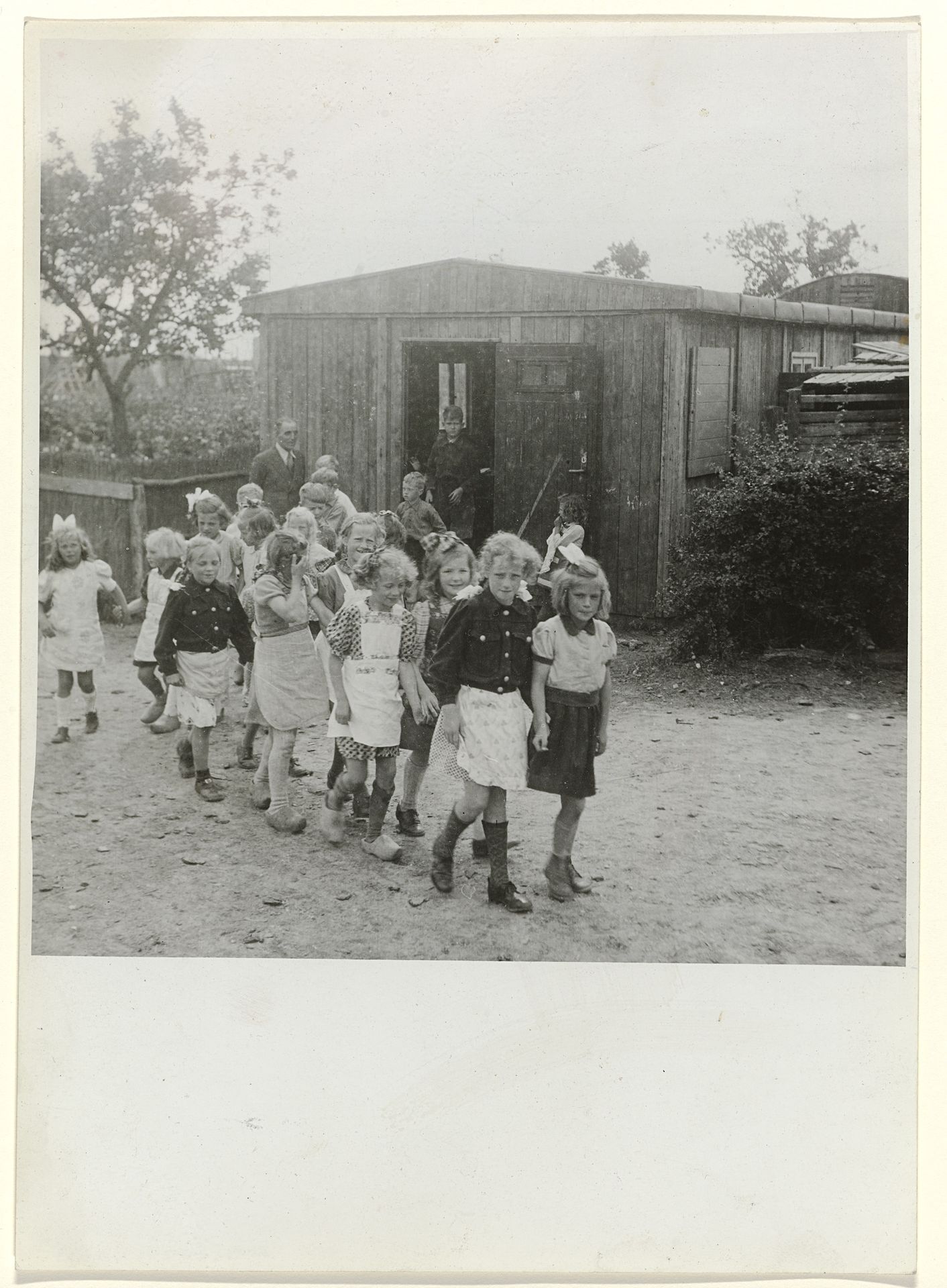 Groep kinderen bij een noodschool by Anefo