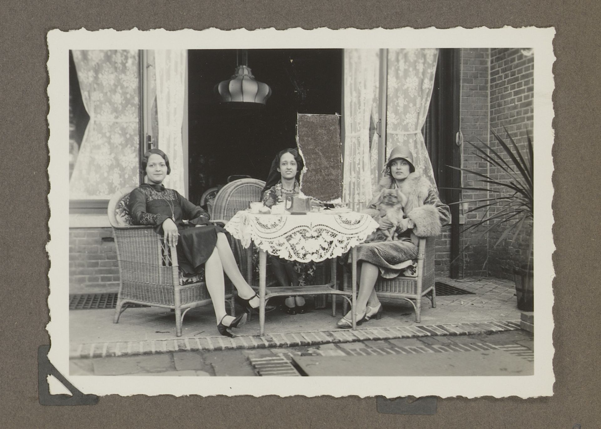 Wilhelmina en Dootje van Zijll de Jong en Henriëtte Wassink zittend aan tafel by Anonymous