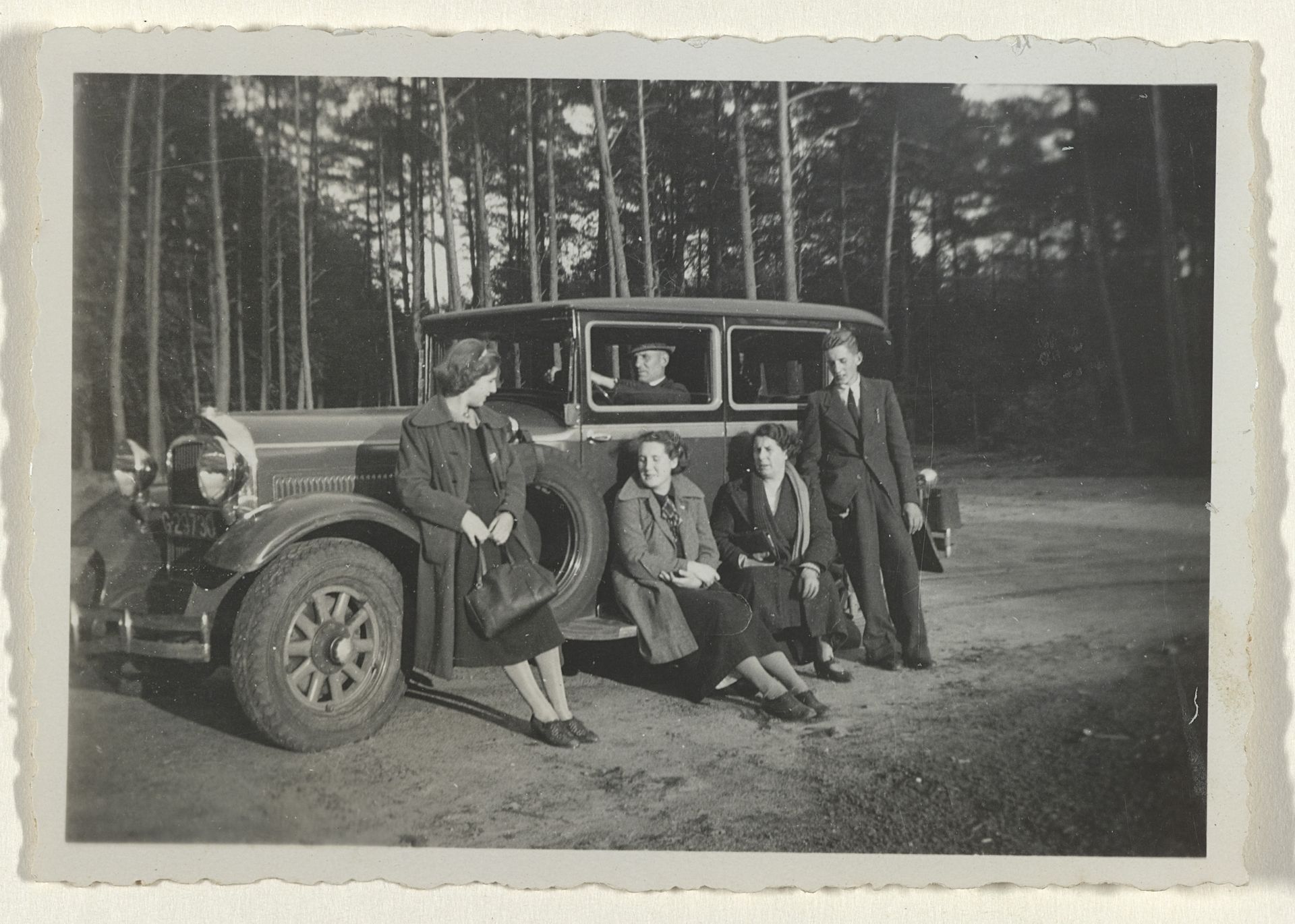 Familie Ochse rondom een auto in het bos by Anonymous