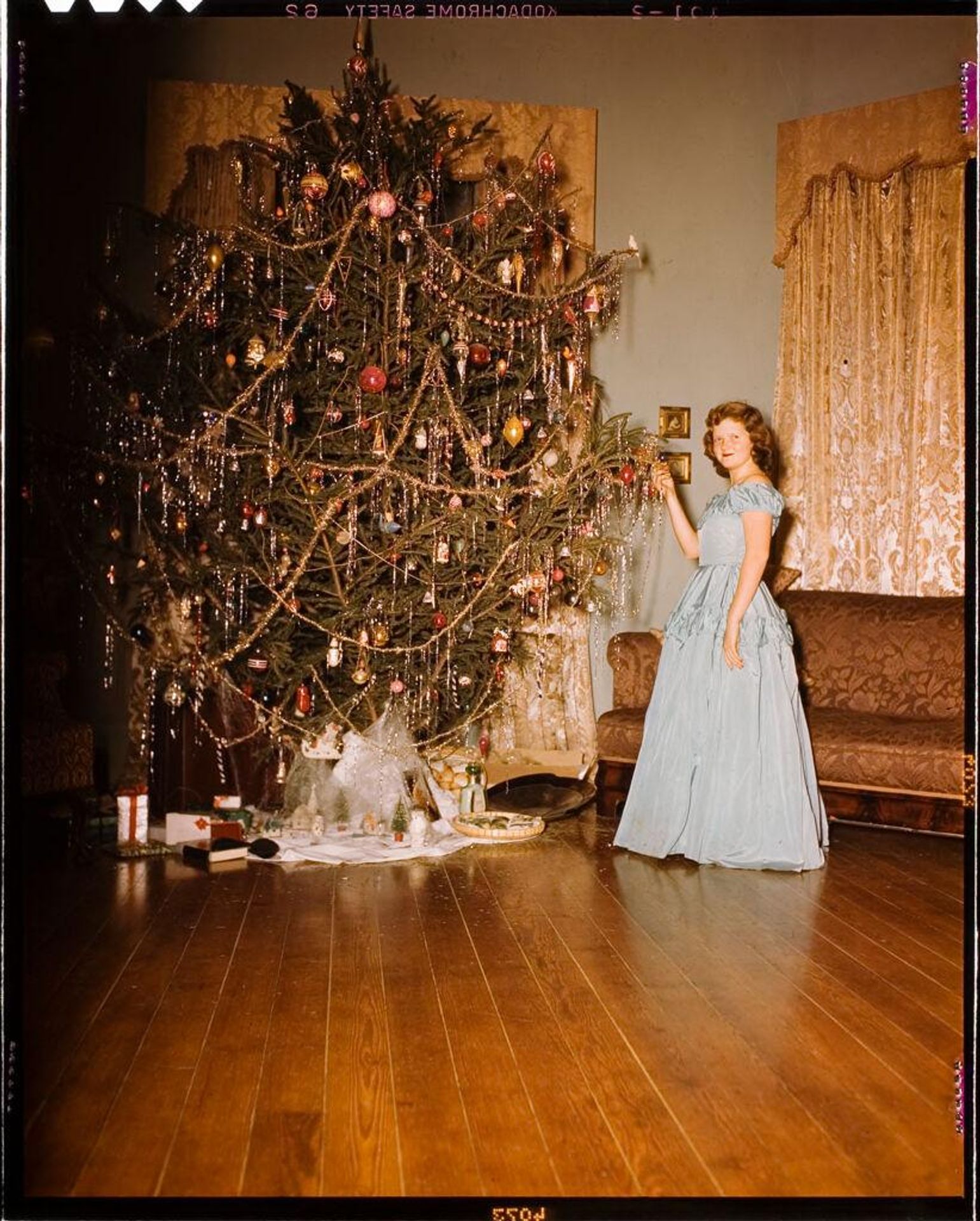 Untitled (young woman next to Christmas tree) by C. Bennette Moore