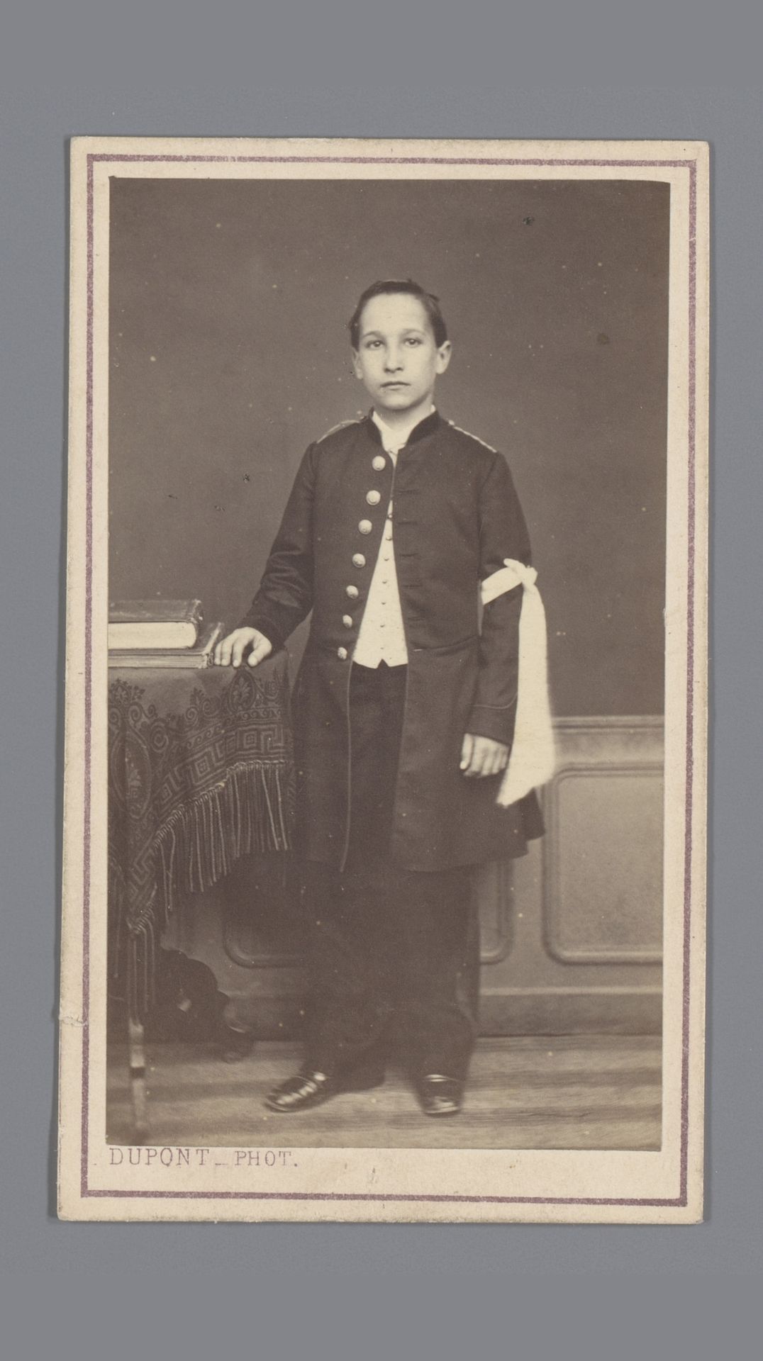 Portret van een onbekende jongen met een strik om zijn arm by Louis Désiré Dupont