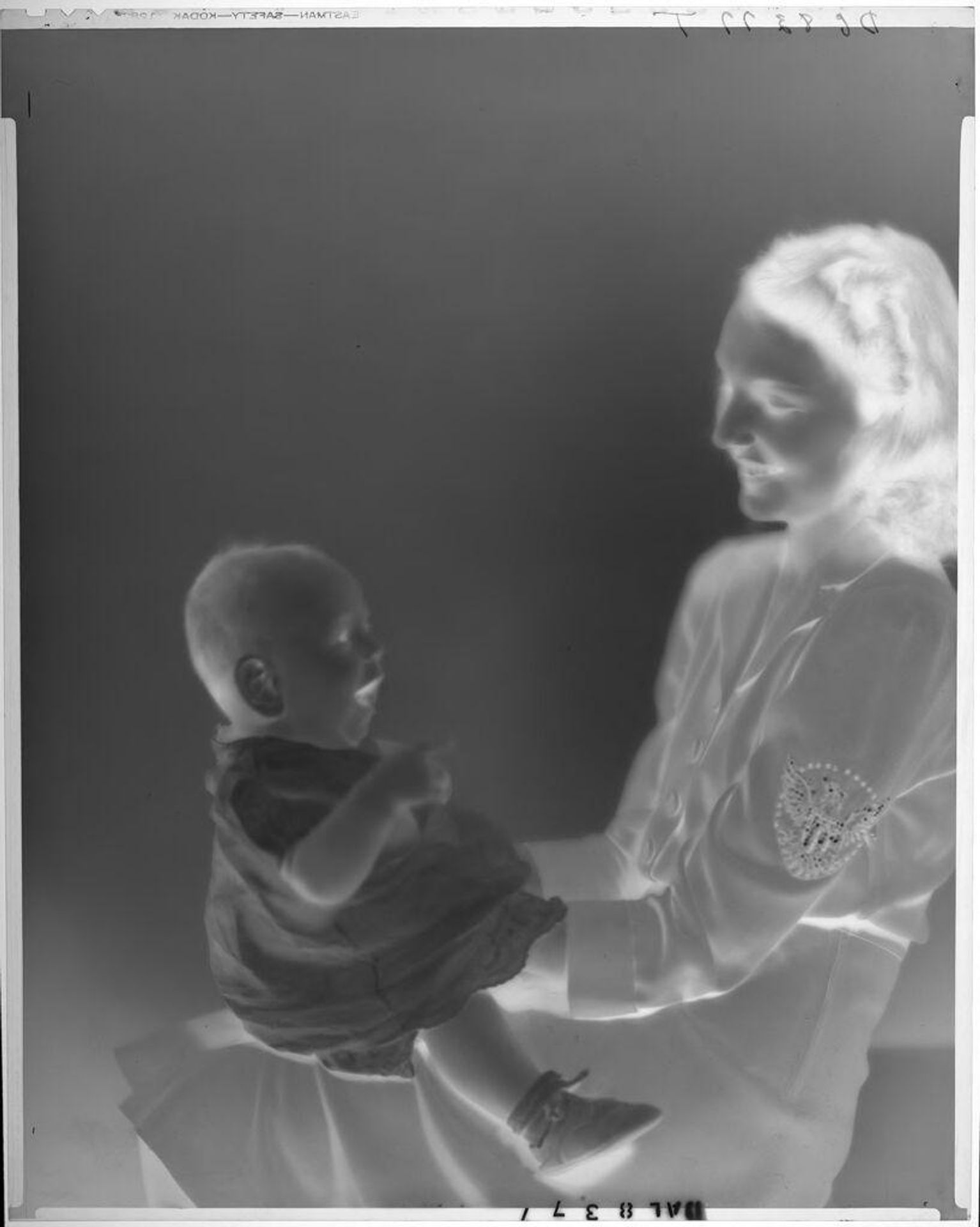 Untitled (woman smiling at baby on her lap) by Paul Gittings