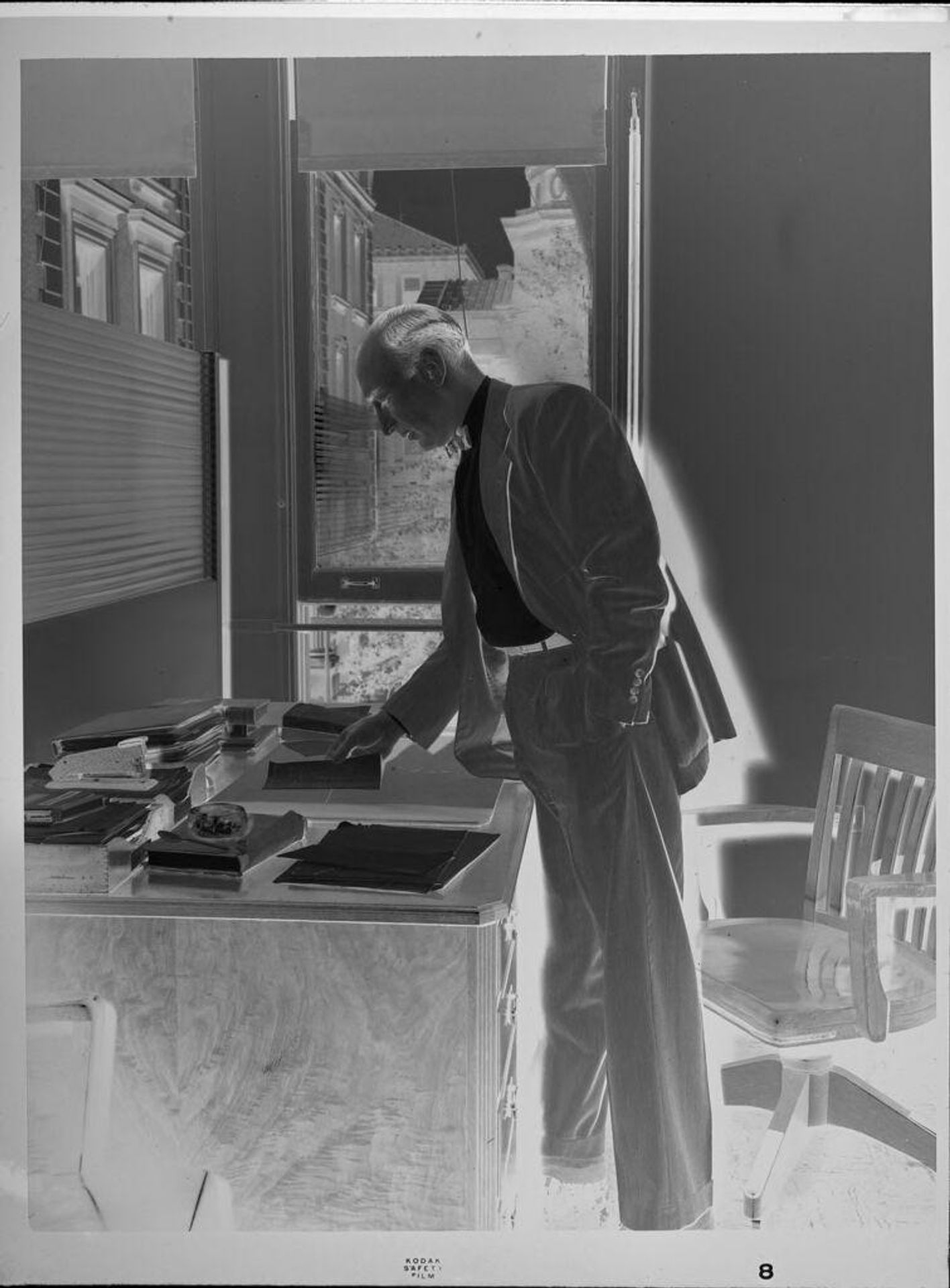 Untitled (professor standing at desk) by Peter James Studio