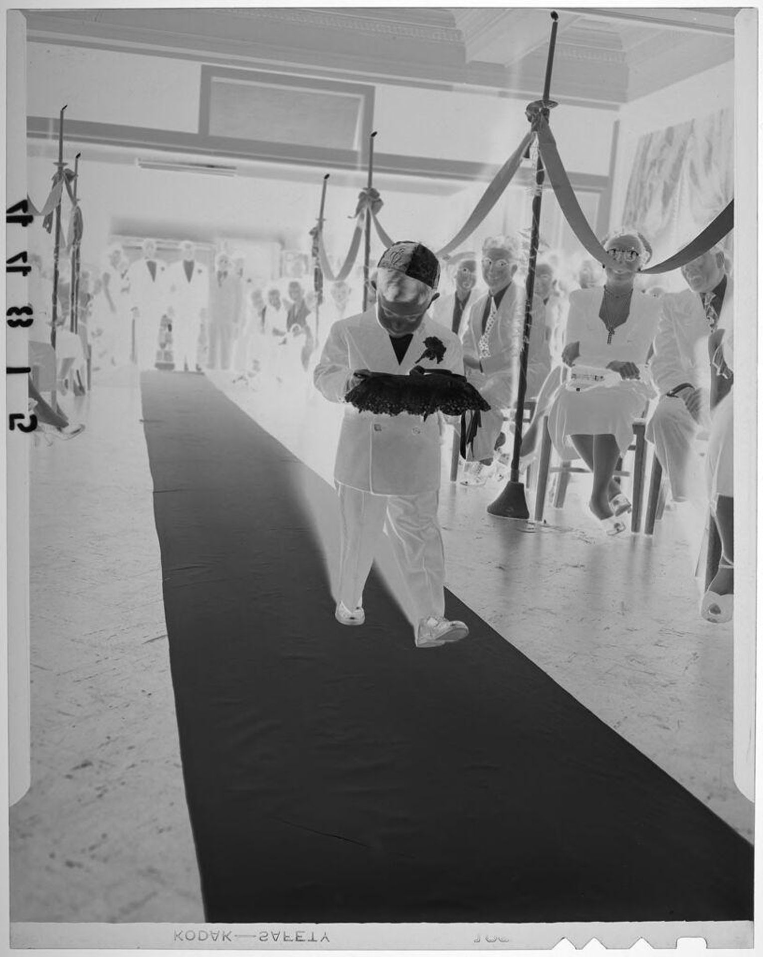 Untitled (young ring boy wearing yarmulke walking down aisle) by Martin Schweig