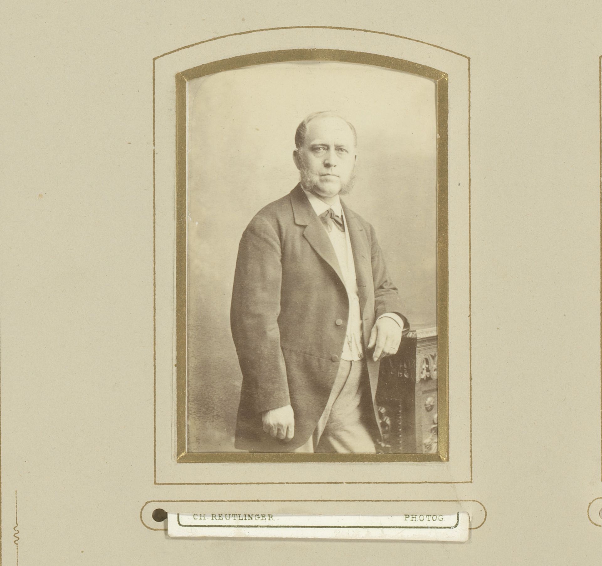 Portret van een man met bakkebaarden, leunend op een kast by Charles Reutlinger