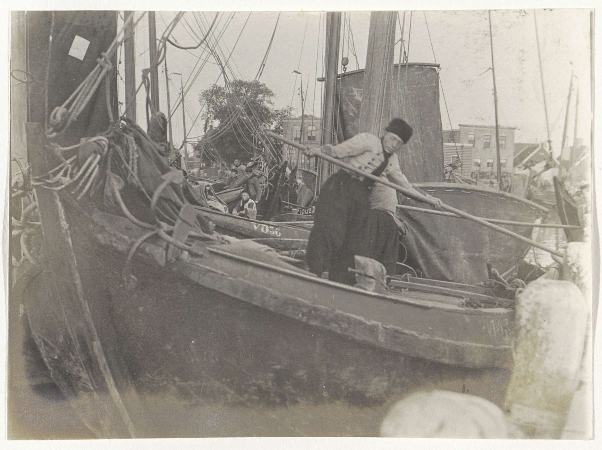 Man in Volendamse klederdracht staand in een zeilschip met een stok in de hand by G. Hidderley